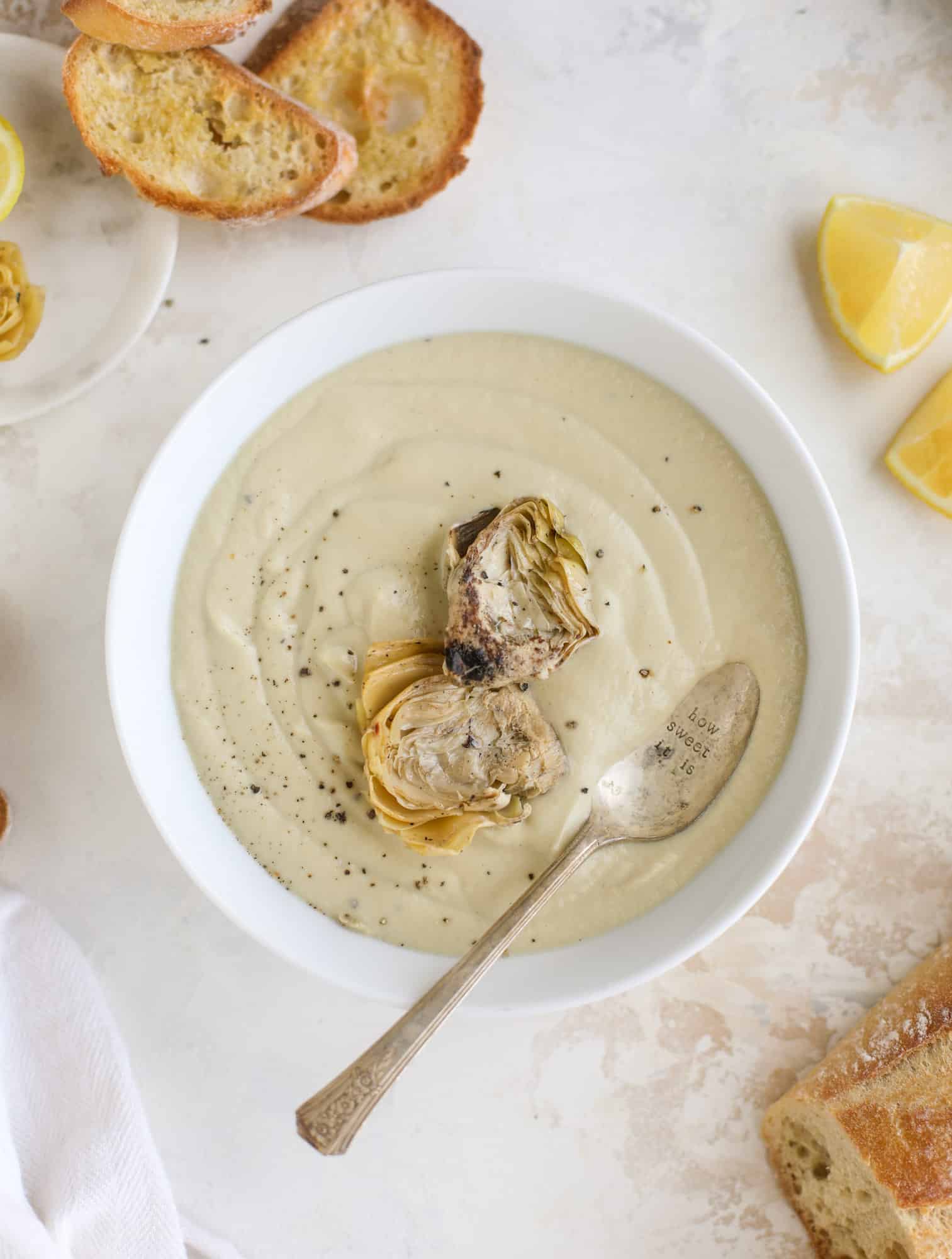 This creamy artichoke soup is full of artichoke hearts, cream and crème fraiche. It's rich and hearty but also light in flavor - perfect for late winter. I howsweeteats.com #artichoke #soup