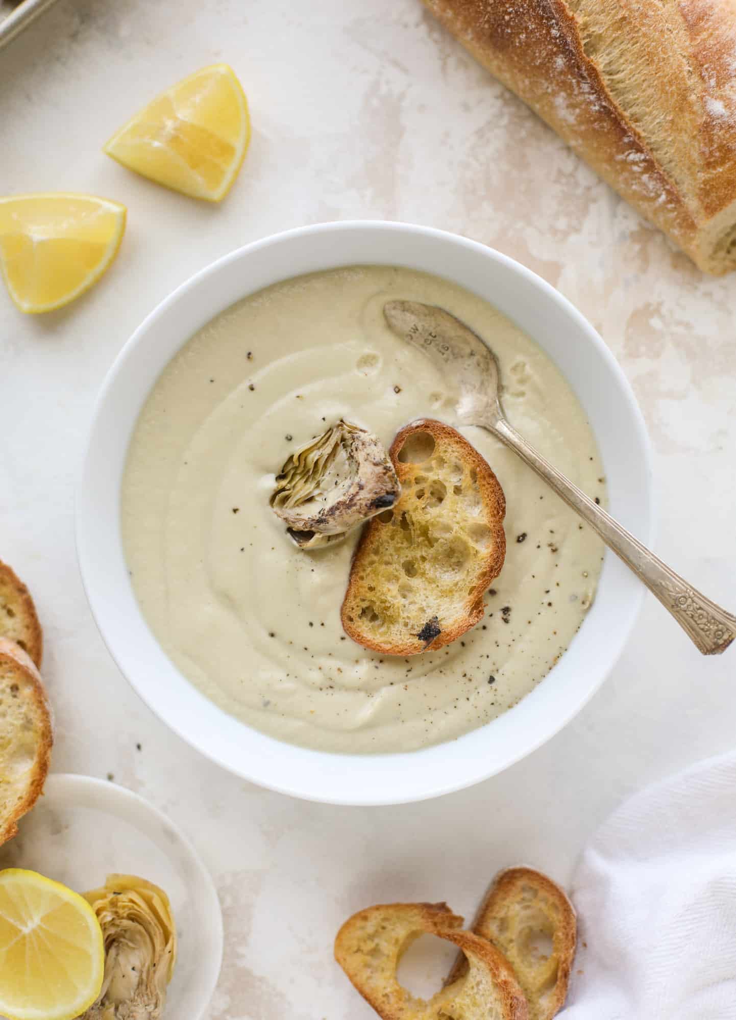 This creamy artichoke soup is full of artichoke hearts, cream and crème fraiche. It's rich and hearty but also light in flavor - perfect for late winter. I howsweeteats.com #artichoke #soup