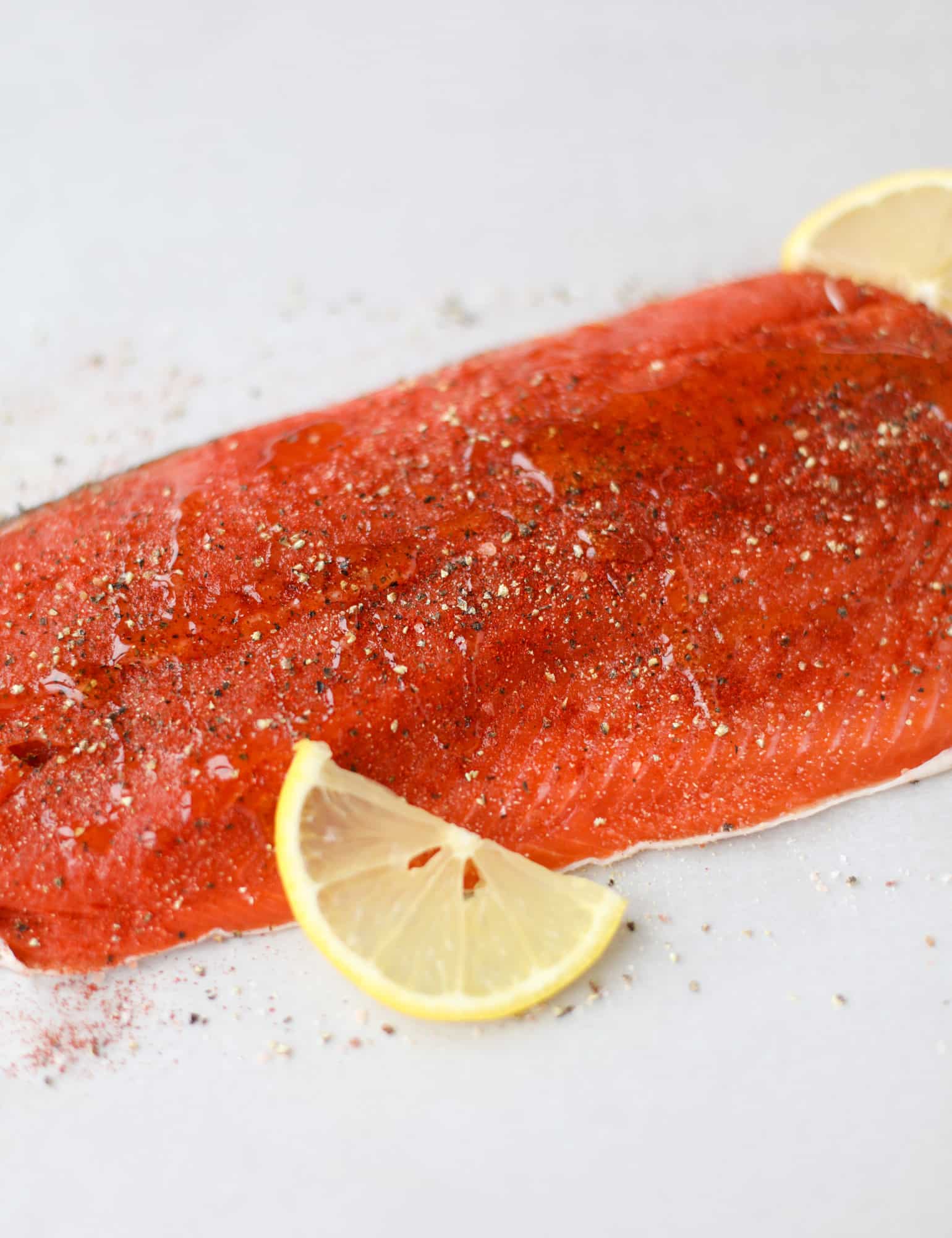 This hot honey salmon is flakey and buttery with a hint of heat and a sprtiz of lemon. It's an easy weeknight meal and is delicious on salads for lunch! I howsweeteats.com #hothoney #salmon