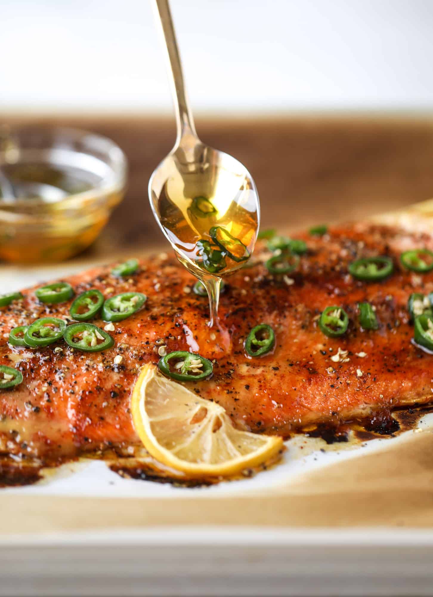 This hot honey salmon is flakey and buttery with a hint of heat and a sprtiz of lemon. It's an easy weeknight meal and is delicious on salads for lunch! I howsweeteats.com #hothoney #salmon