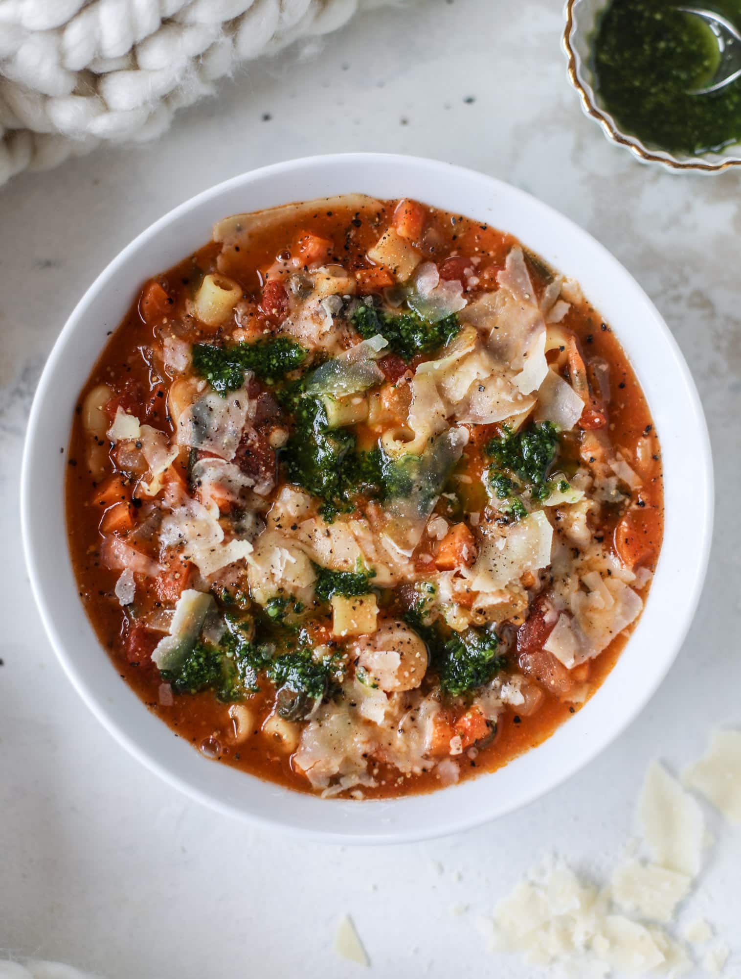 This fire roasted minestrone soup is like a huge in a bowl. Chock full of vegetables, fire roasted tomatoes and butter beans, the bowl is topped off with a delicious kale pesto that adds even more flavor. Satisfying, healthy and perfect for dinner! I howsweeteats.com #minestrone #soup