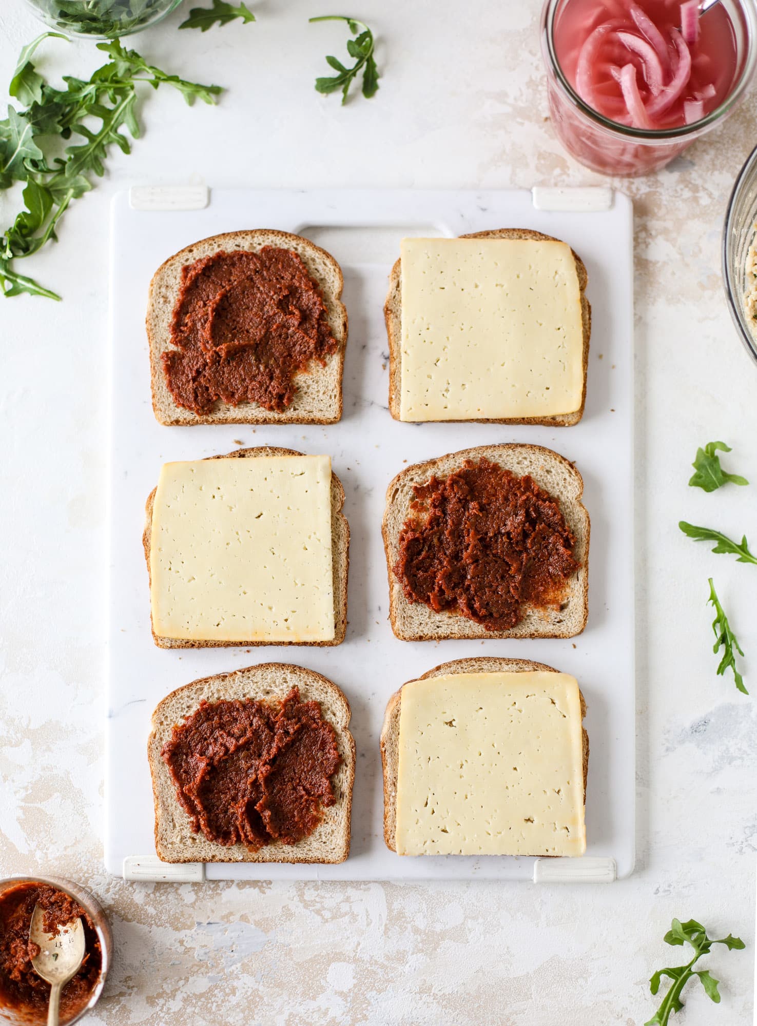 This tuscan tuna melt is a modern way to enjoy a tuna sandwich, with peppery arugula, melty cheese, pickled onions and sun dried tomato spread! I howsweeteats.com #tuna #melt
