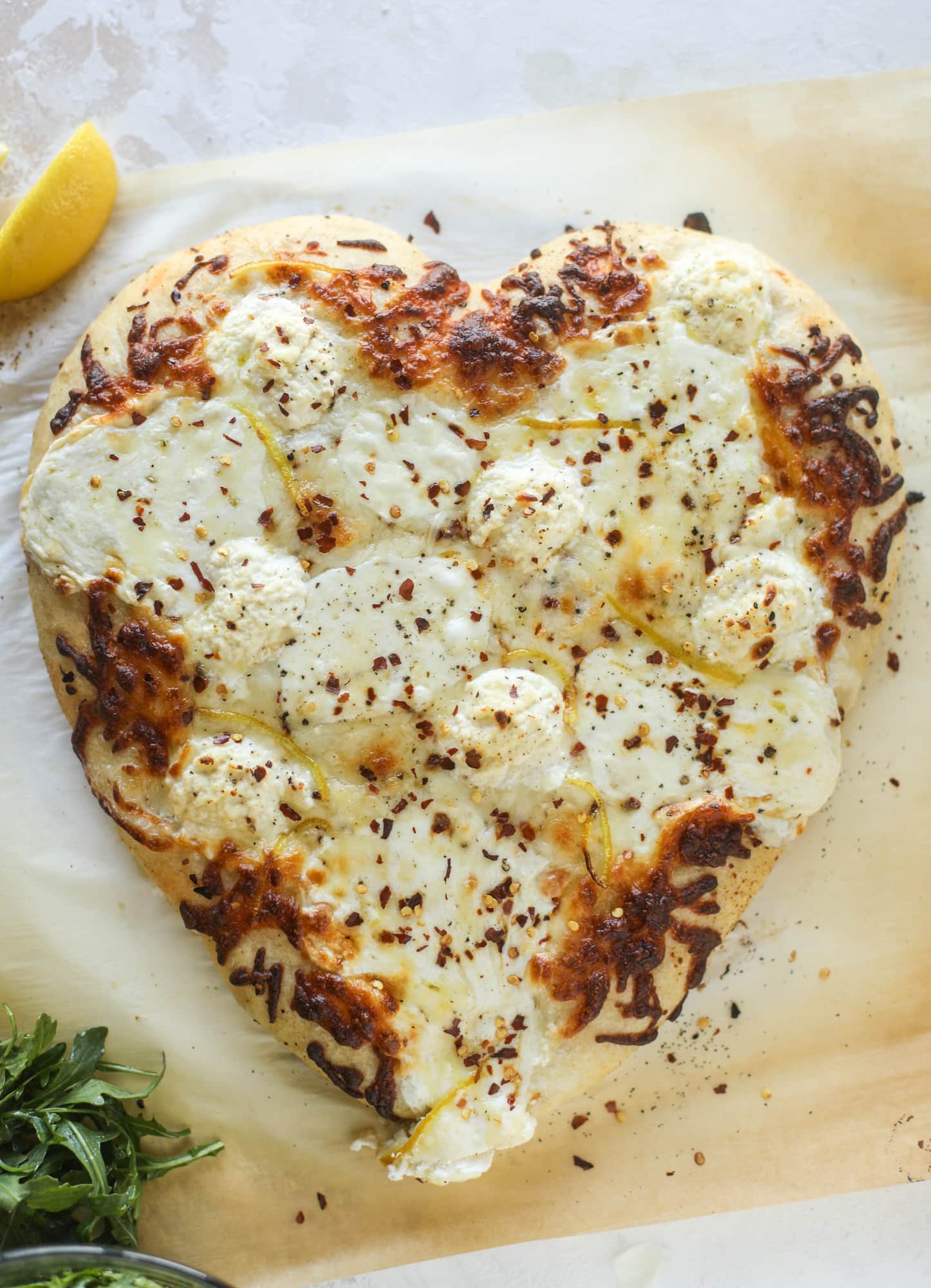 Our favorite white pizza recipe has four different kinds of cheese and comes on a garlic bread crust! Topped with crushed pepper and lemon - tons of flavor! I howsweeteats.com #white #pizza