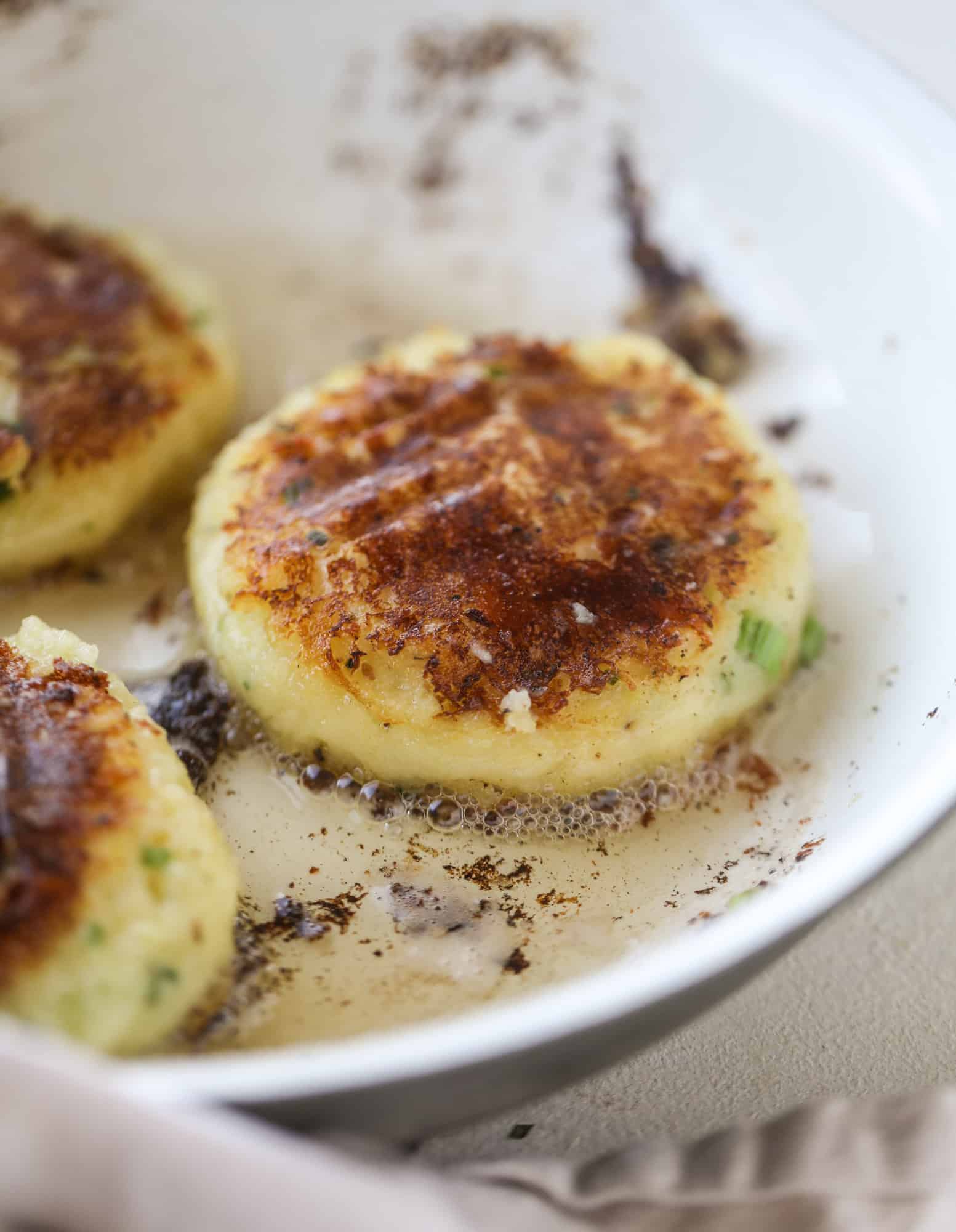 Loaded mashed potato pancakes are the perfect comfort food or side dish to a hearty meat. Crispy mashed potatoes with aged cheddar. Delicious! I howsweeteats.com #mashedpotato #pancakes