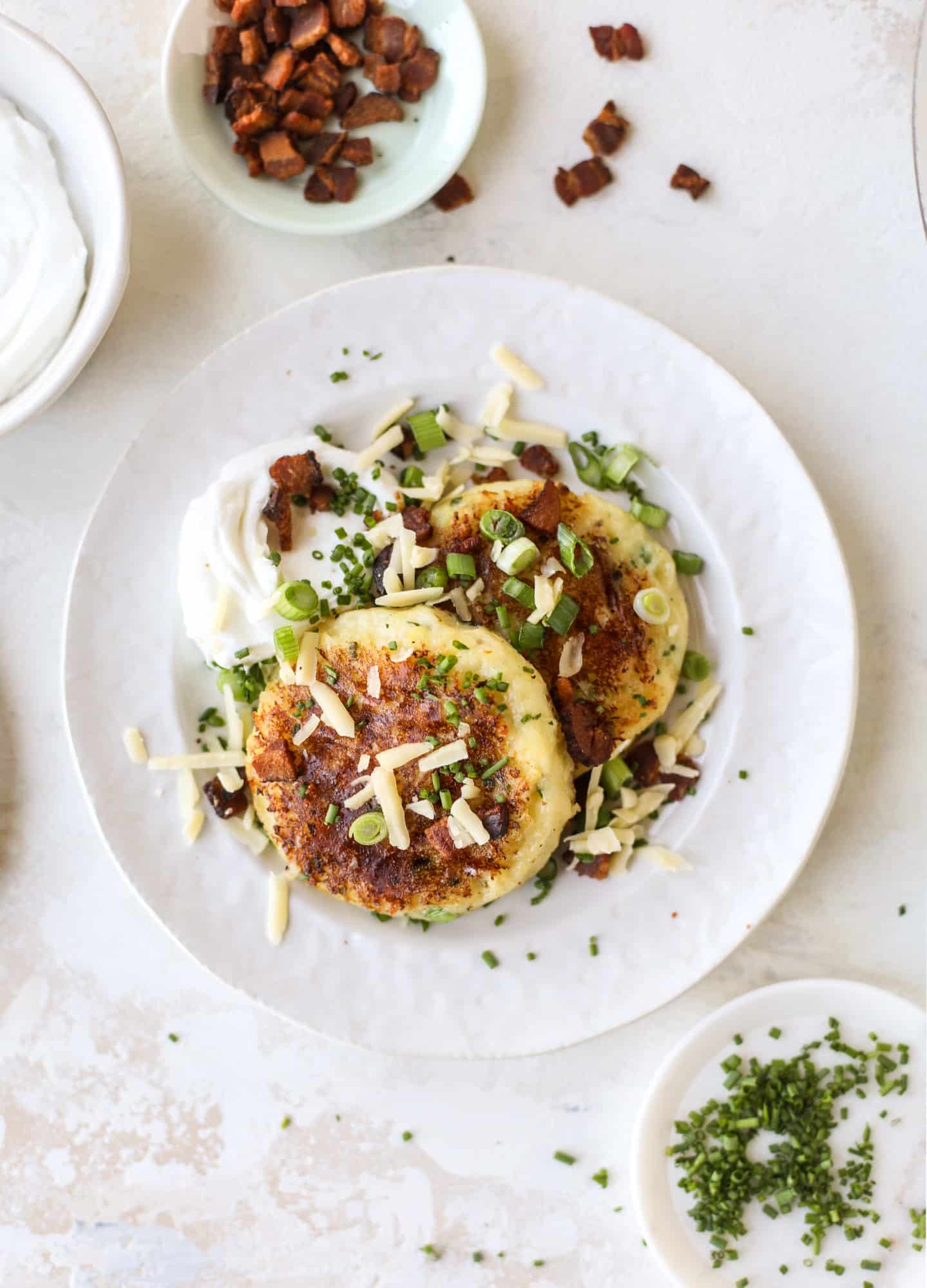 Loaded-mashed potato pancakes are the perfect comfort food or side dish to a hearty meat. Crispy mashed potatoes with aged cheddar. Delicious! I howsweeteats.com #mashedpotato #pancakes