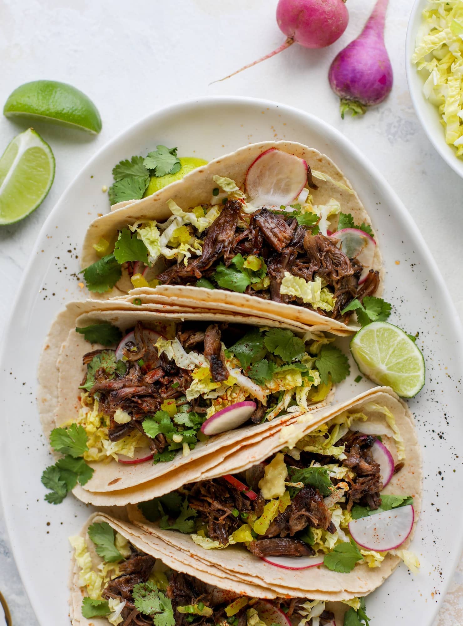 These are the best smoky short rib tacos made in the slow cooker! Served with a banana pepper mustard and napa cabbage slaw, it's a flavor explosion.