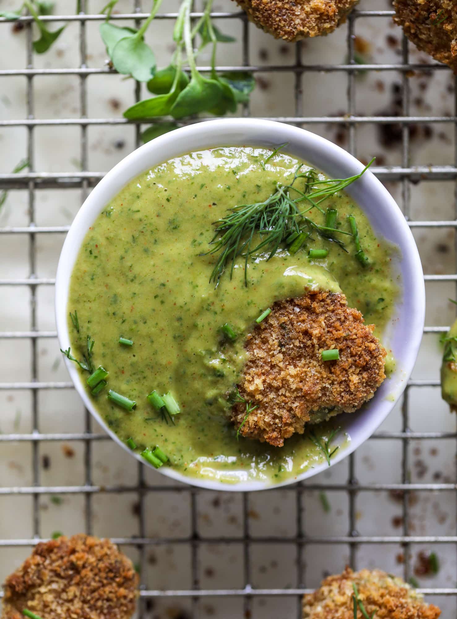 Oven fried crispy pickles are super crunchy and delicious! Served with a dairy free green goddess ranch dip, they are the best snack ever.