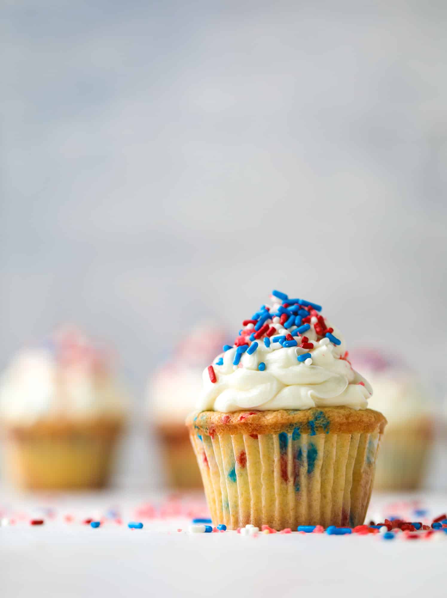 These 4th of July confetti cupcakes are super fun! Firecracker cupcakes with red, white and blue sprinkles and pop rocks candy on top for crackle!