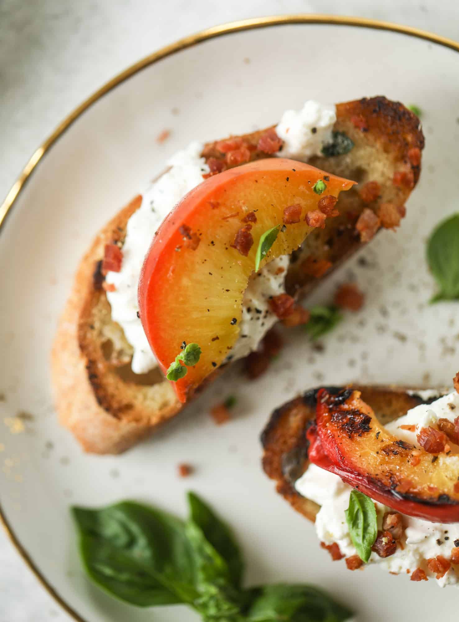 This peach burrata crostini is the best summer appetizer! it starts with grilled basil butter toasts that are topped with burrata, peach and pancetta!