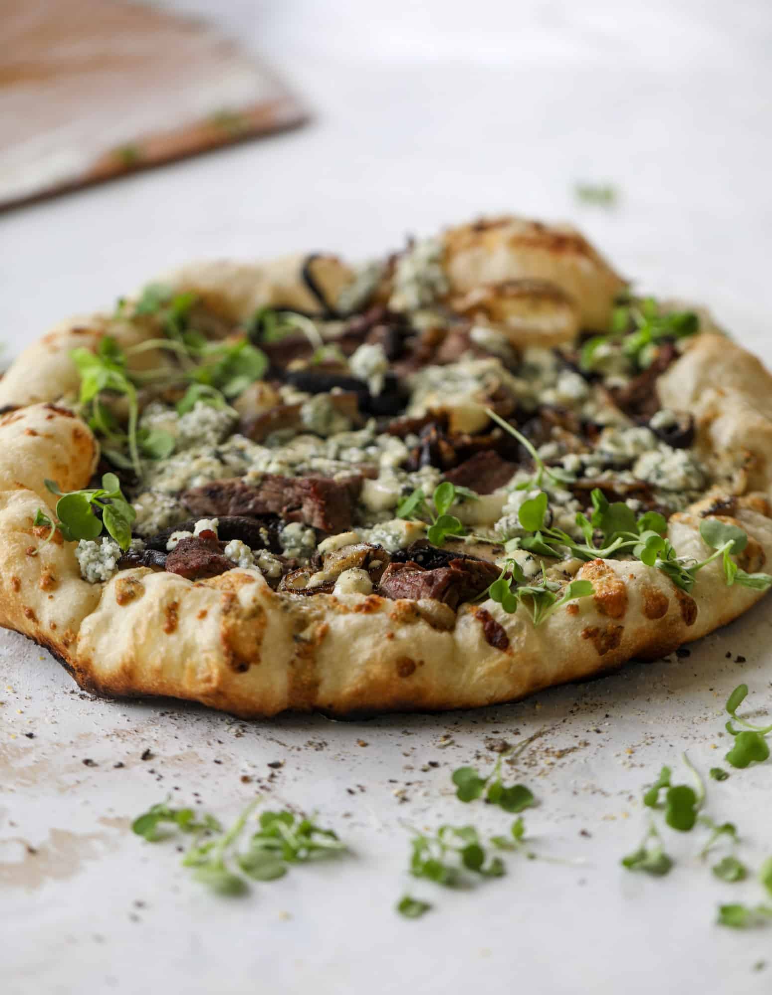 This grilled steakhouse pizza has all the amazing smoky flavors of your favorite steakhouse. Grilled onions, mushrooms and creamy gorgonzola finish it off.