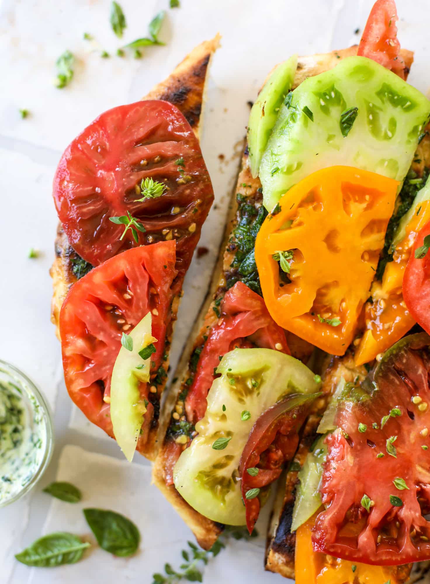 This heirloom tomato pizza starts with a grilled garlic herb butter crust! Melty herb butter and sliced fresh tomatoes top it off for a delicious bite!