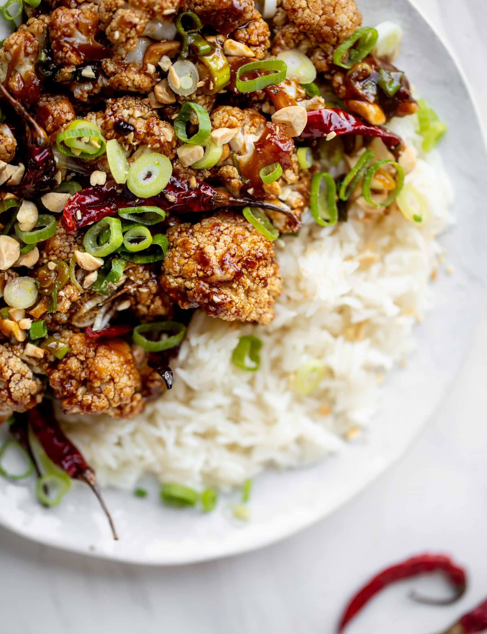 This kung pao cauliflower recipe is roasted on one sheet pan and covered in a delicious sauce! Serve alongside jasmine rice for the best dinner ever.