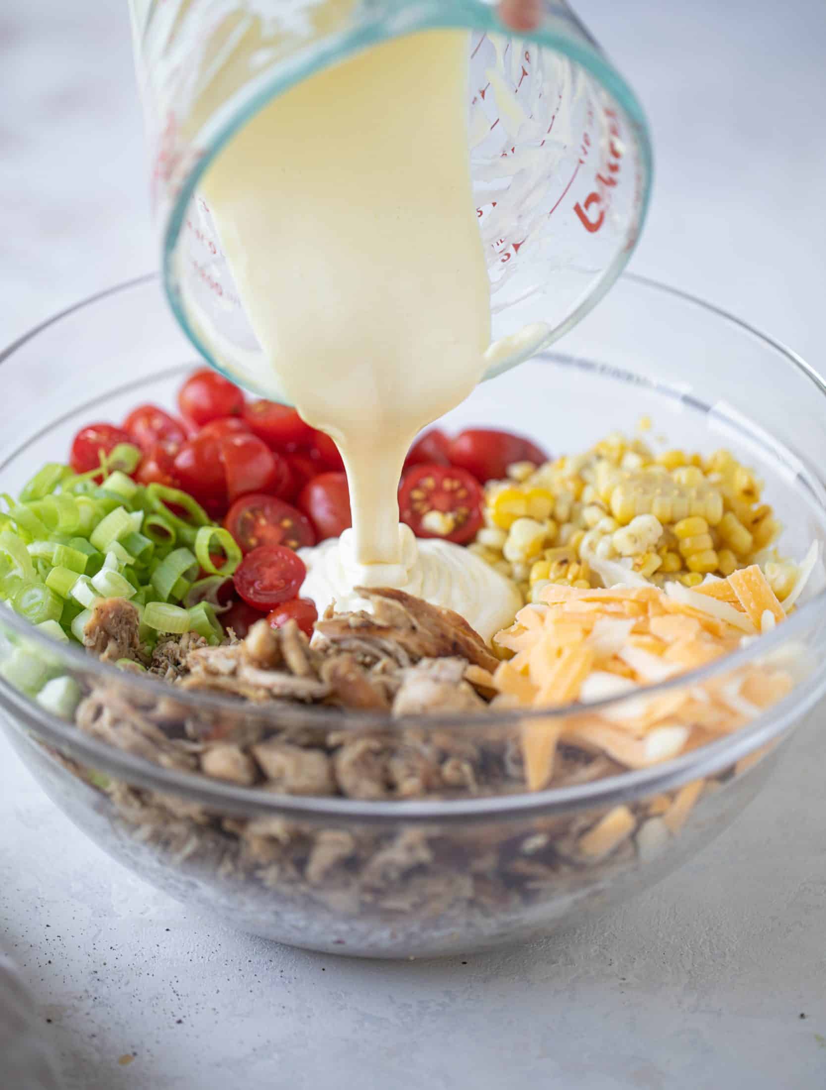 This smoky summer chicken salad is incredible! So much flavor from grilled chicken, sweet cherry tomatoes, corn, cheddar cheese and a secret ingredient!