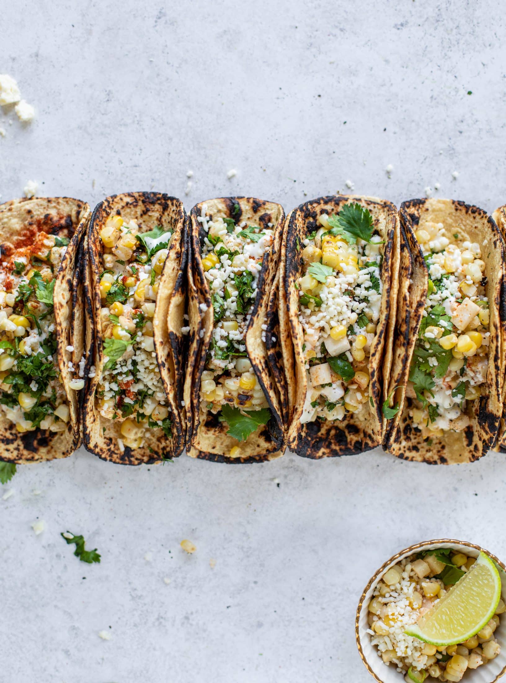 These street corn tacos are filled with a jicama corn salad and drizzled with garlic mayo. This little taco packs a major flavor punch.