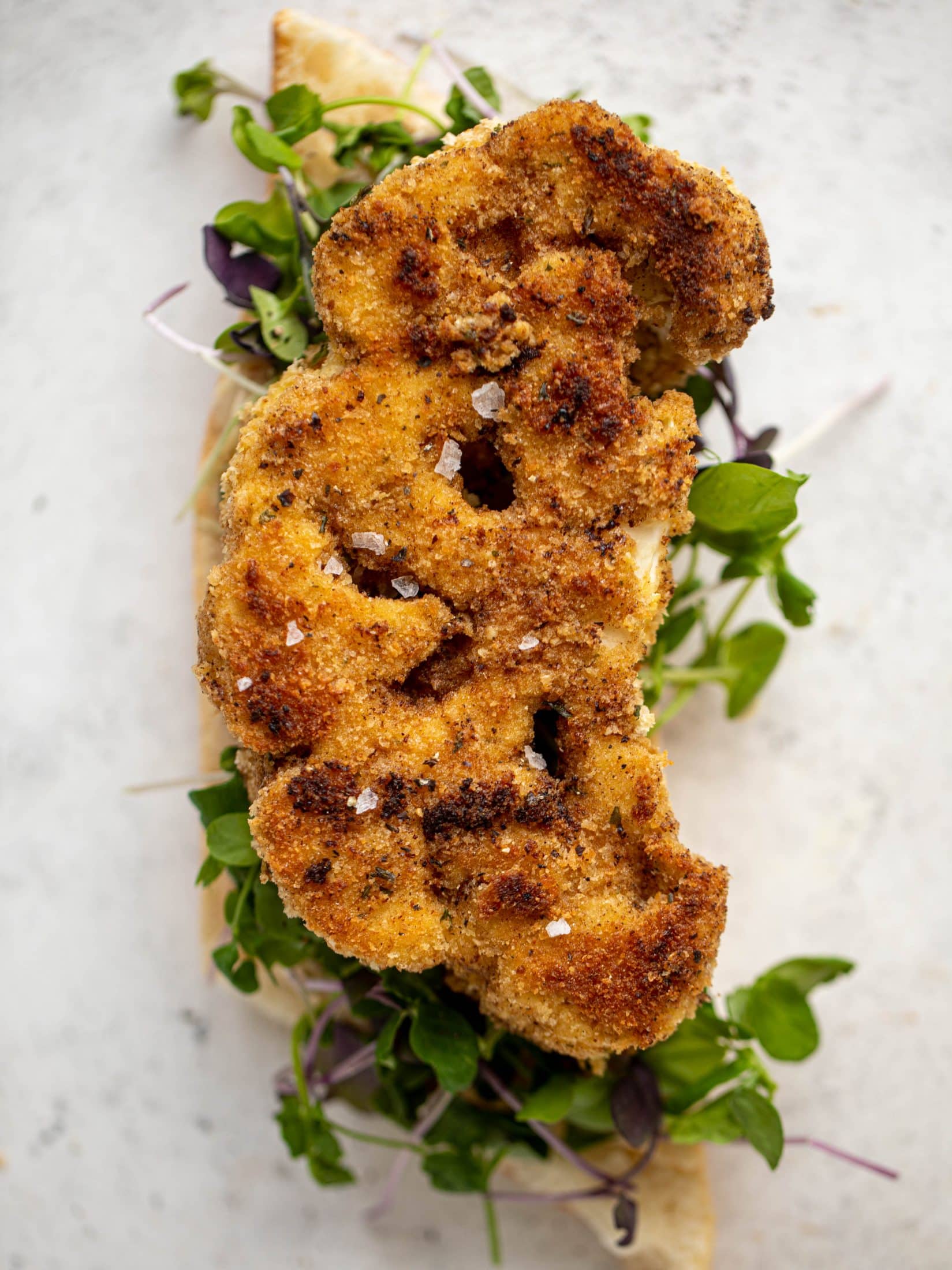 These cauliflower schnitzel sandwiches are full of flavor! Crispy cauliflower, caramelized onion mayo, pickled cabbage and microgreens. Delish!