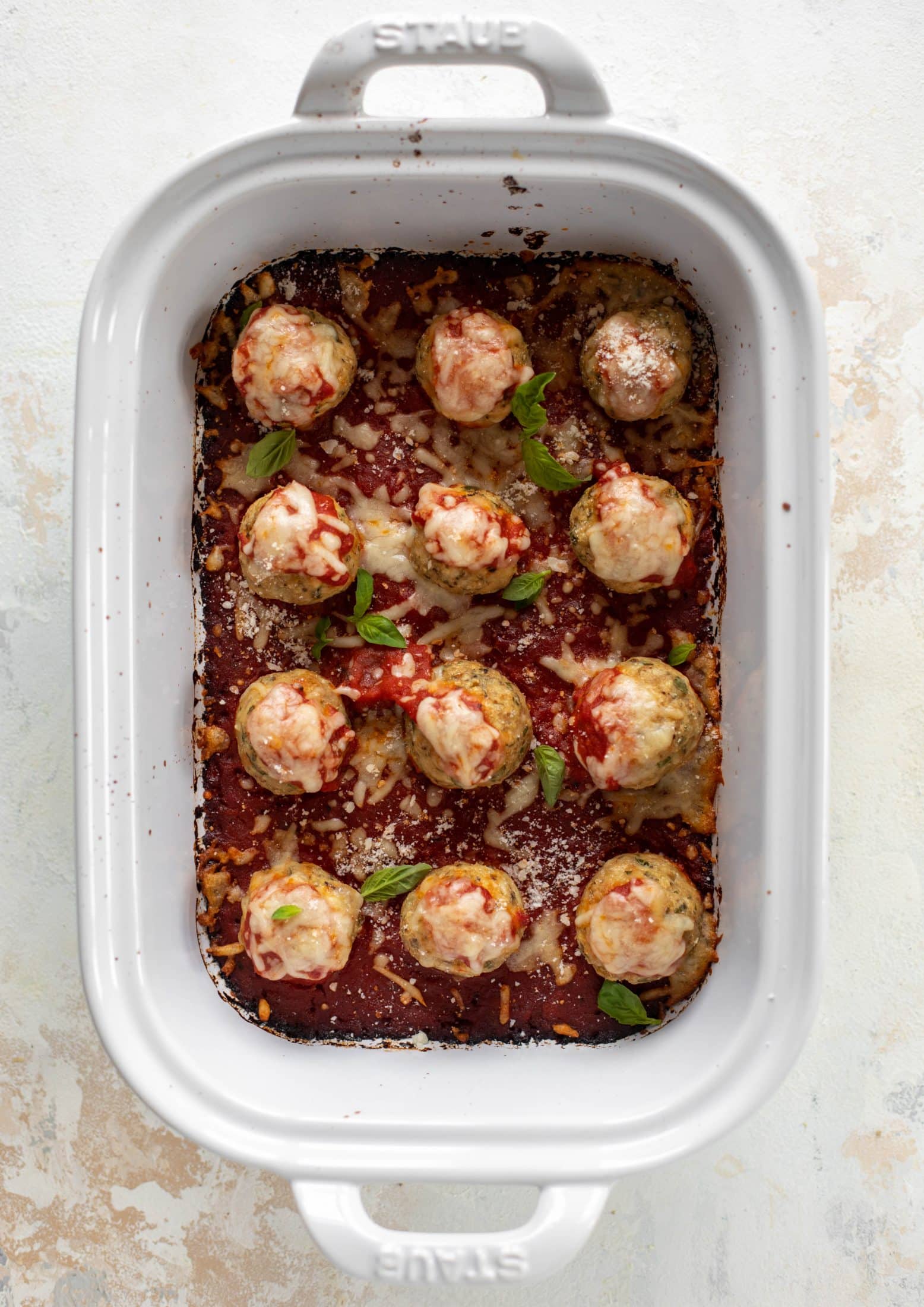 Chicken parmesan meatballs are baked and super flavorful! Serve with roasted garlic spaghetti for the best dinner ever! You can make them ahead of time too!