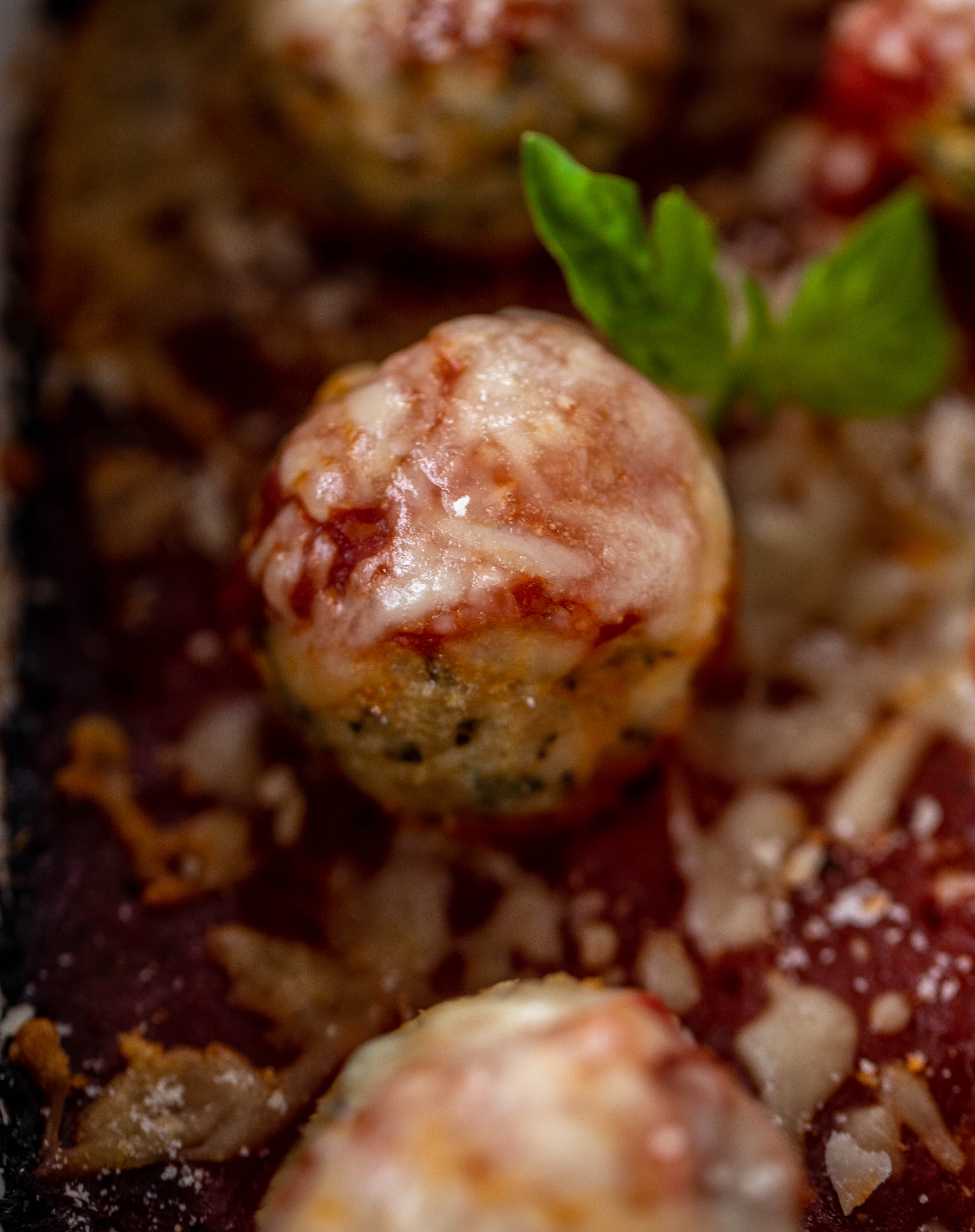 Chicken parmesan meatballs are baked and super flavorful! Serve with roasted garlic spaghetti for the best dinner ever! You can make them ahead of time too!