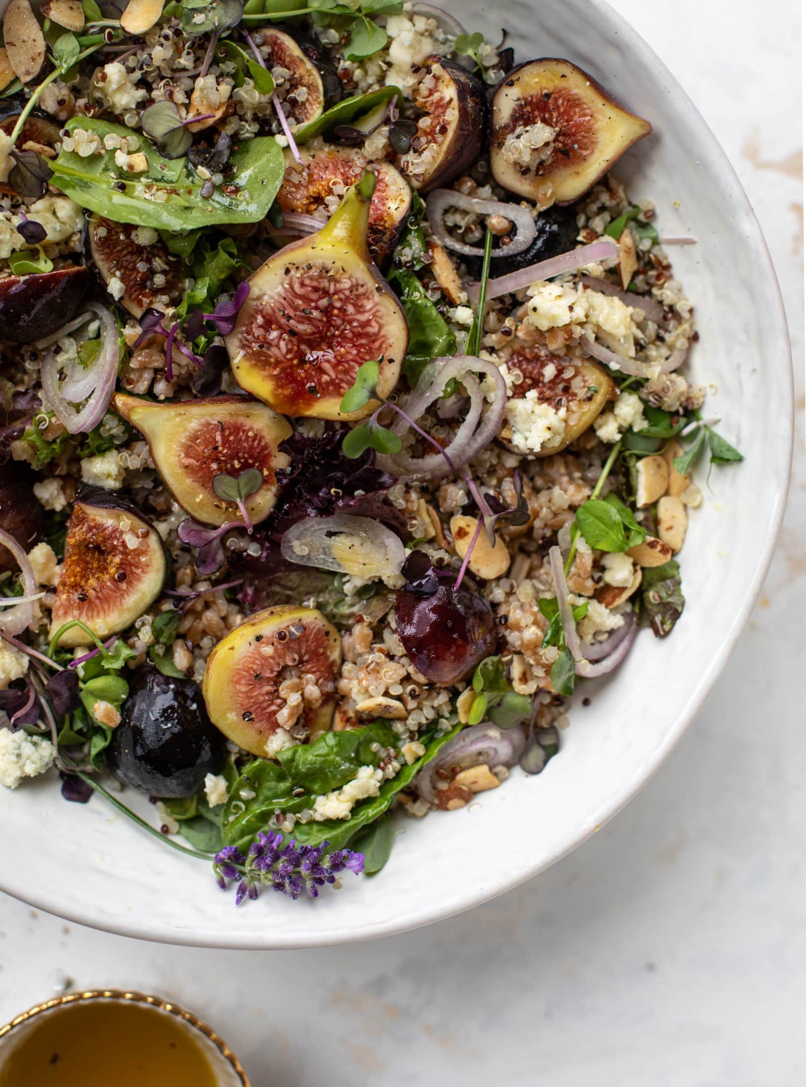 These grain bowls are the perfect September salad! Juicy figs, greens, quinoa, farro, almonds and a lemon lavender vinaigrette make this bowl irresistible.