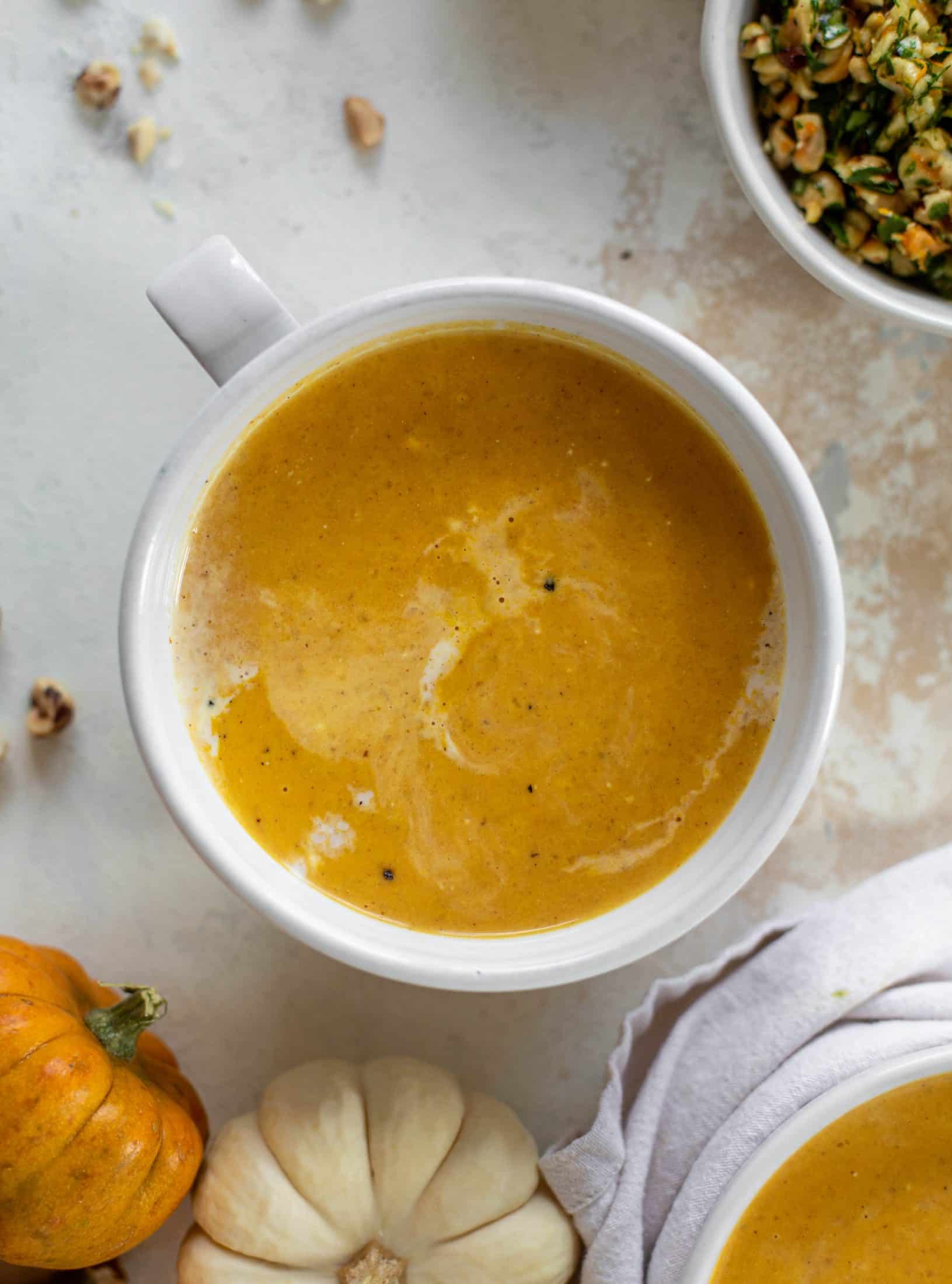 This pumpkin cream soup is silky smooth and delicious, then topped with a roasted hazelnut gremolata for extra flavor and crunch!