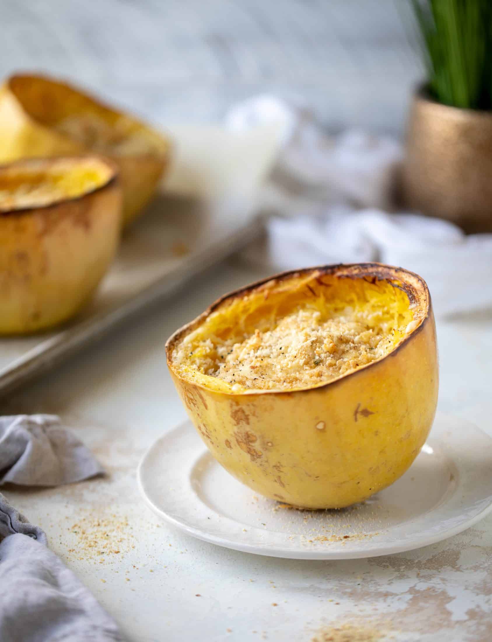 Three cheese spaghetti squash in a squash bowl! Squash tossed with fontina, gruyere and parmesan to make a creamy comforting meal.