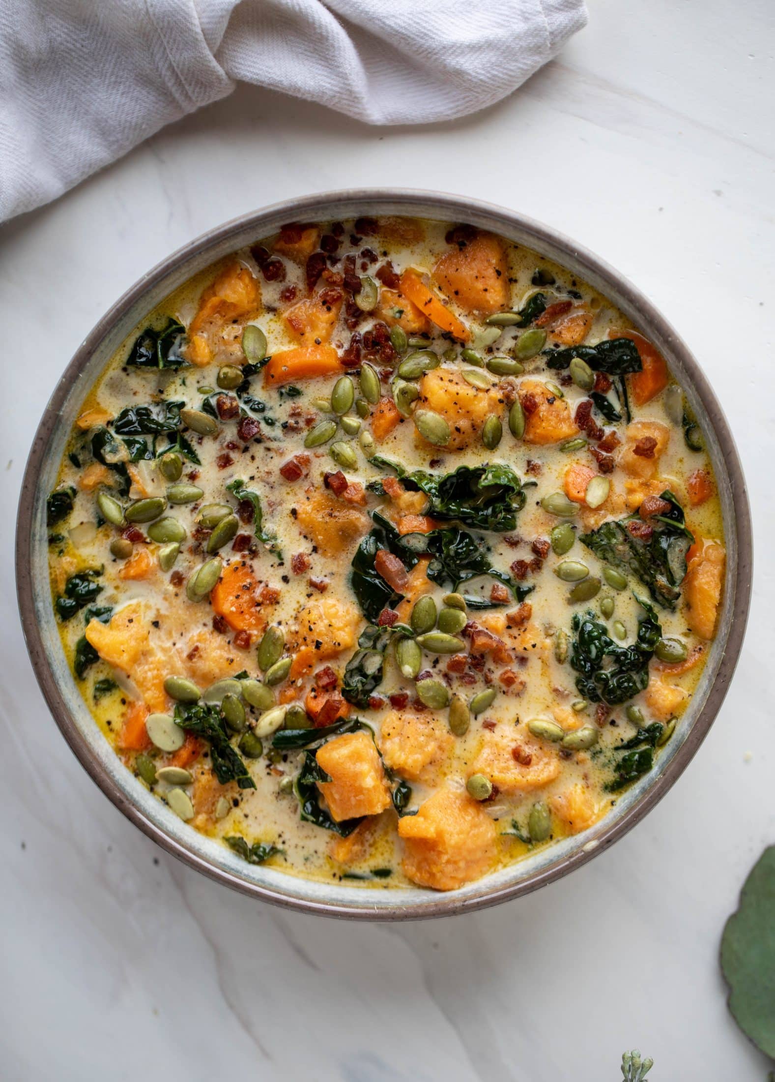 This sweet potato chowder is a hug in a bowl! Made with lots of greens and crunchy pancetta and pepitas for topping, it's a perfect weeknight meal.