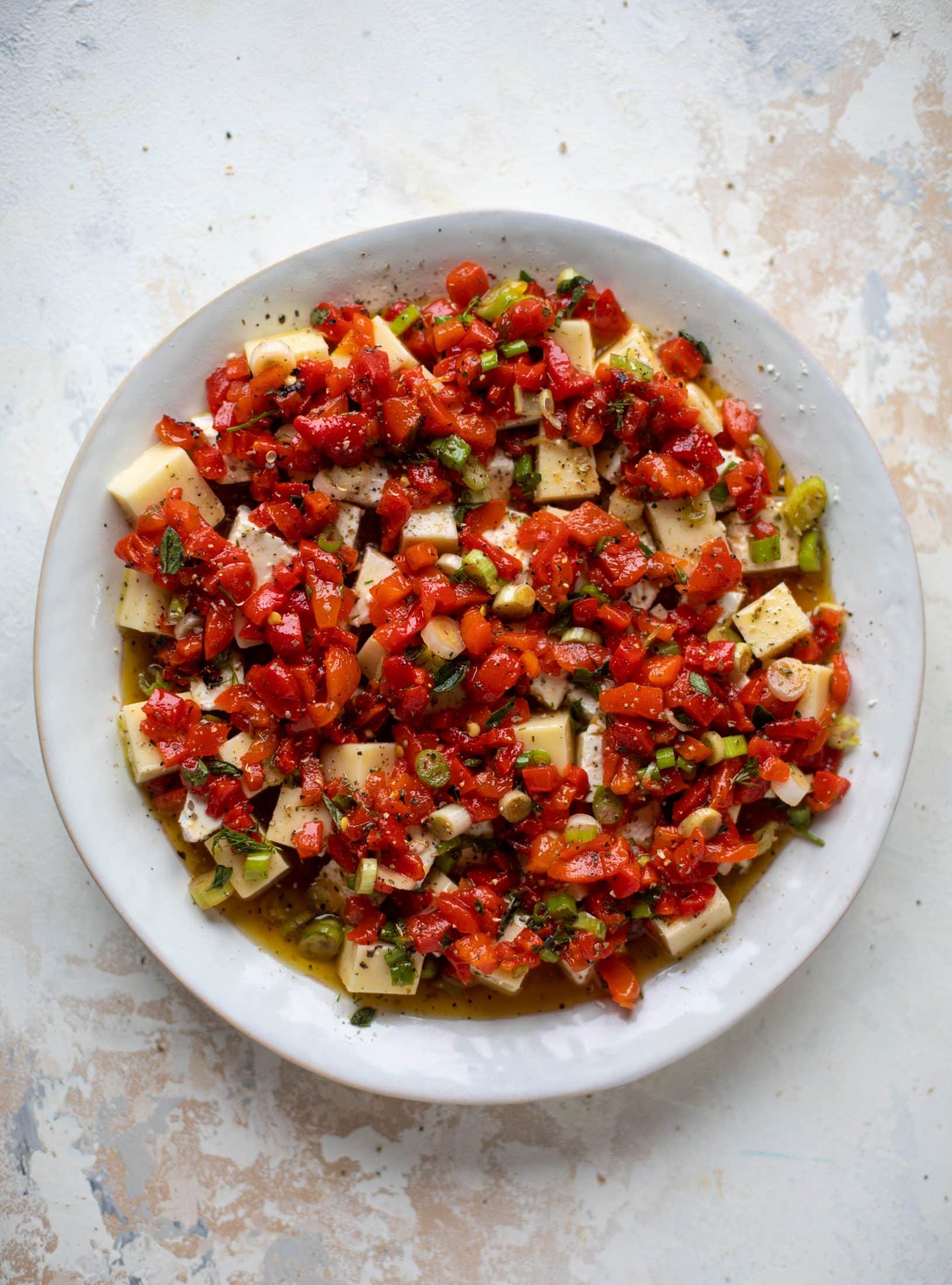 This marinated cheese recipe is perfect for Christmas! Make it ahead and transport it easily to your destination. It's absolutely delicious.