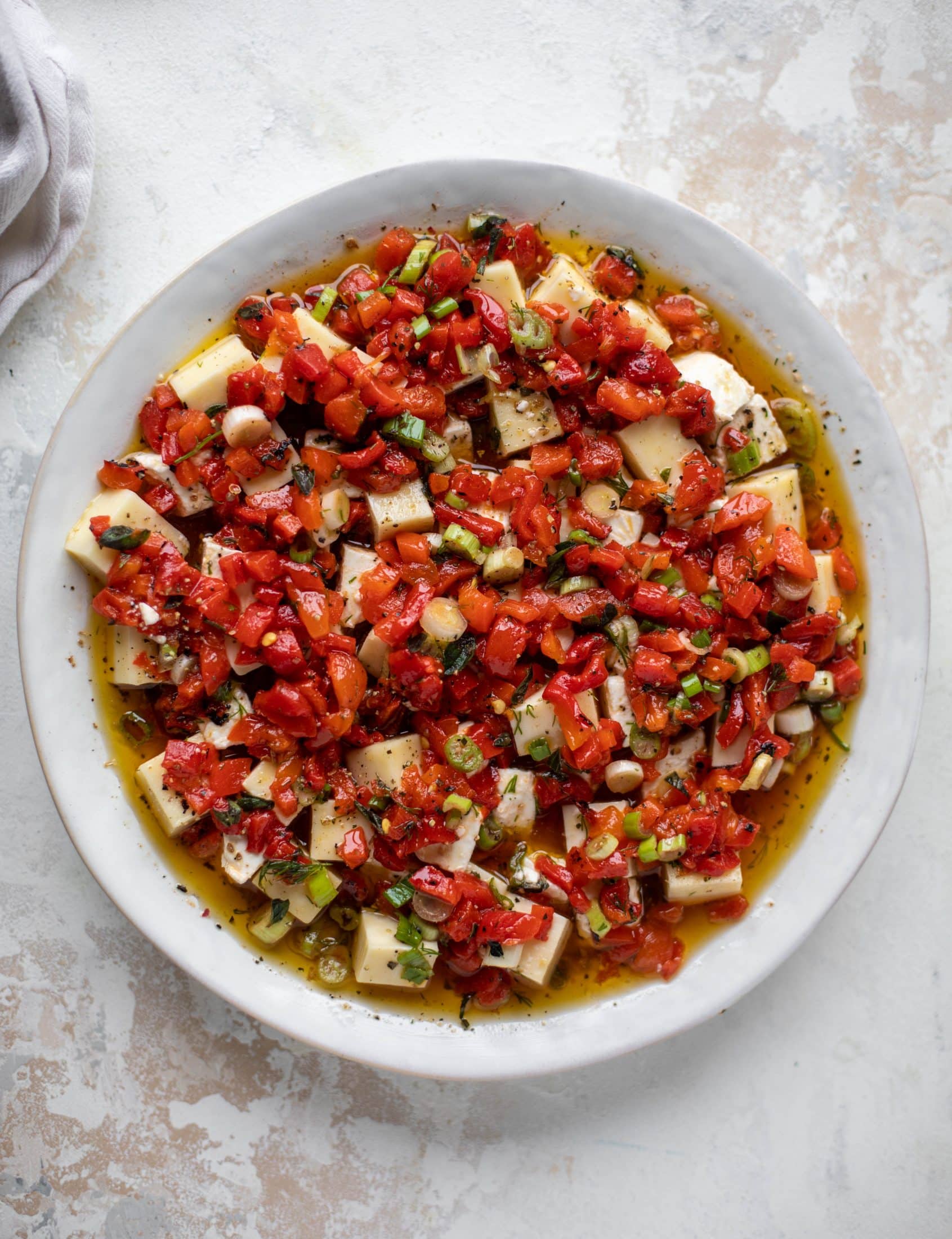 This marinated cheese recipe is perfect for Christmas! Make it ahead and transport it easily to your destination. It's absolutely delicious.