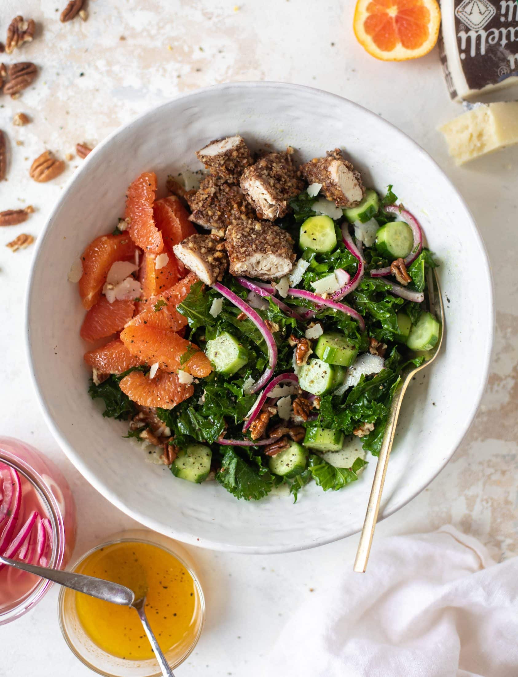 This pecan crusted chicken salad is so hearty! Kale, cara cara oranges, pickled onions, cucumbers and pecorino make this a bowl of flavor.