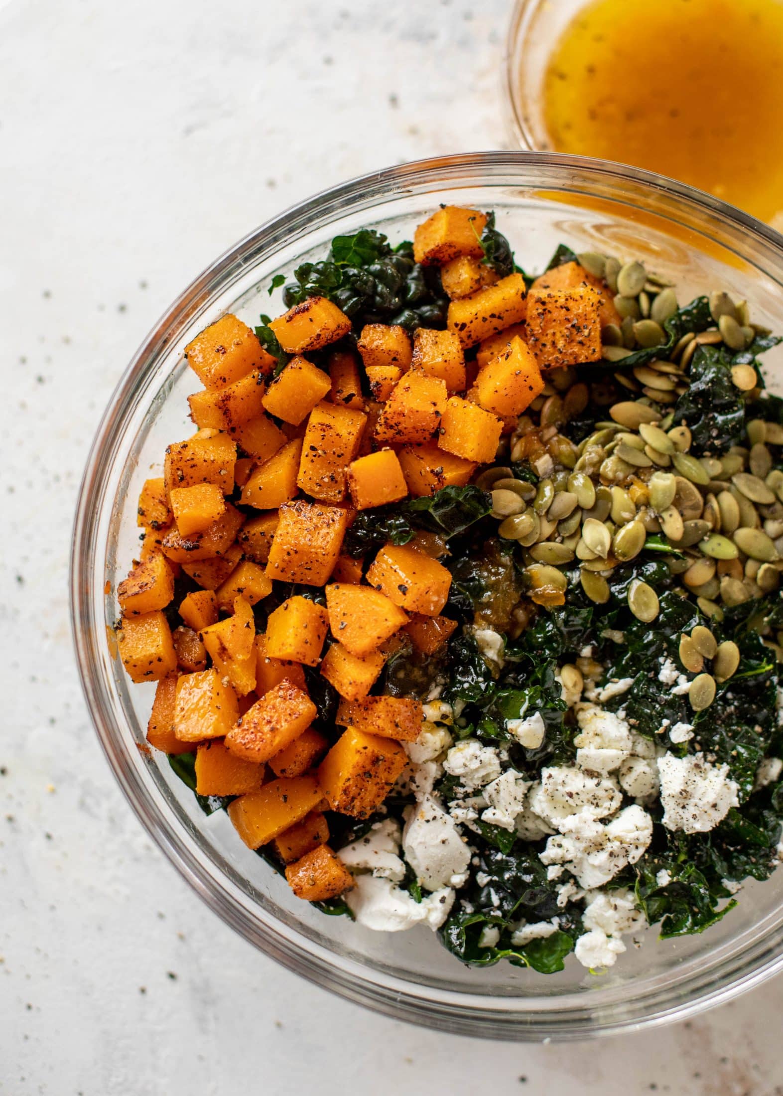 This butternut squash kale salad is so easy and delicious! Roasted, smoky butternut squash, goat cheese, pepitas and apricot vinaigrette.