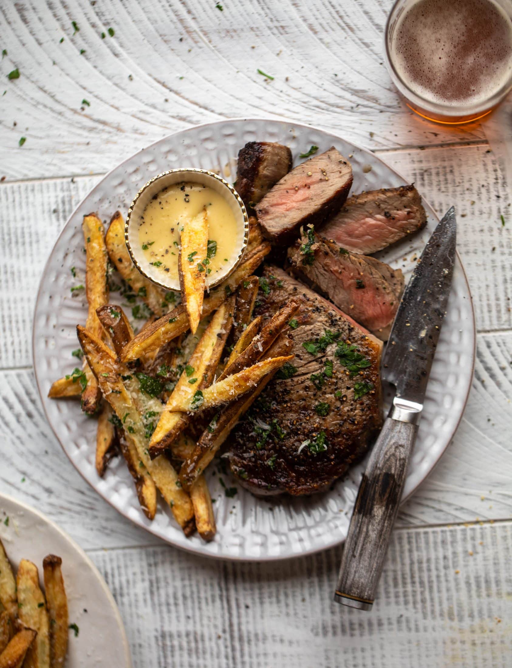 This is our favorite steak frites! Seared skillet steak and crispy fries made in the air fryer, topped with truffle salt, parmesan and herbs!