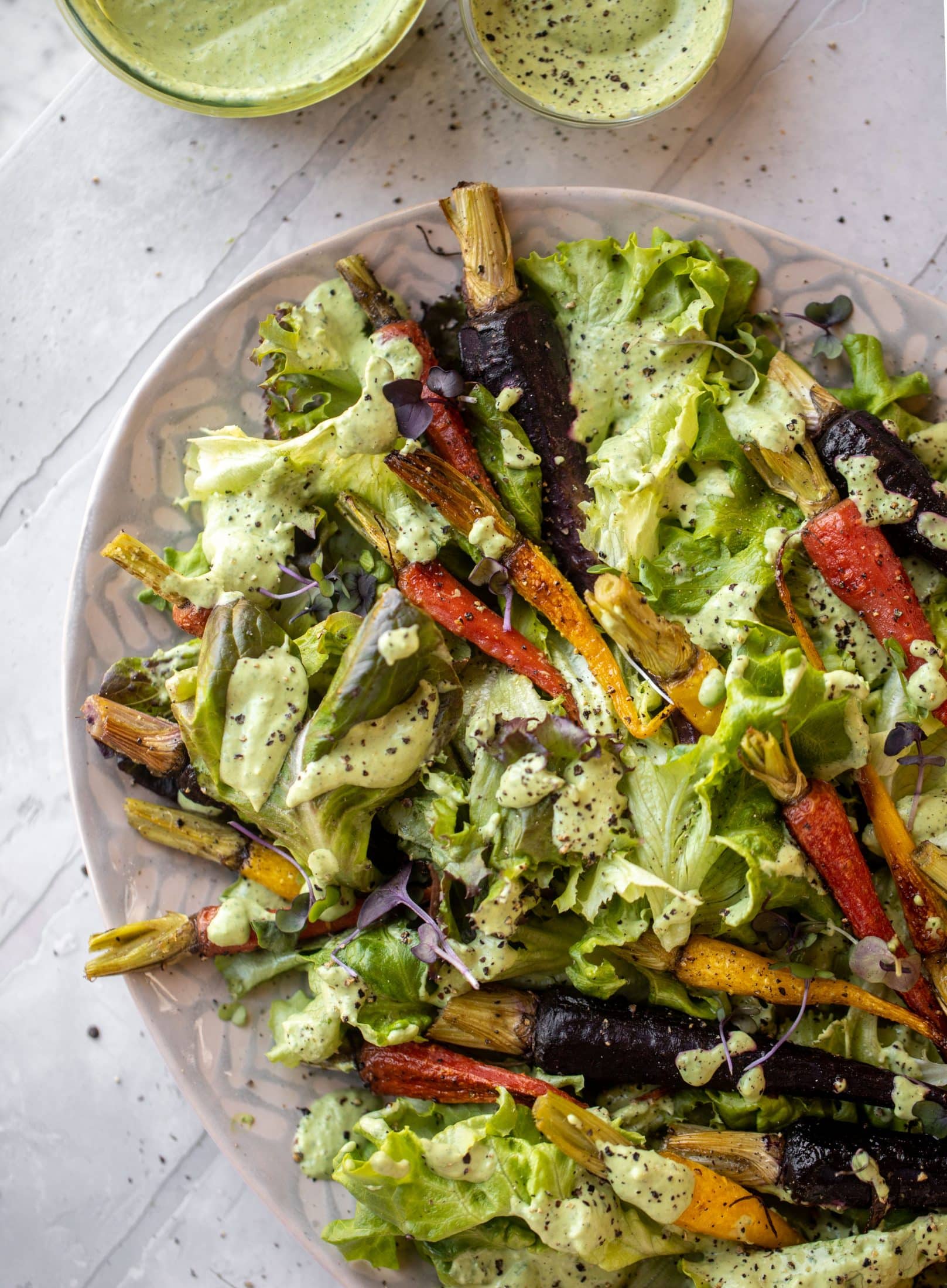 This roasted carrot salad is perfect for spring! Caramely, roasted carrots served over butter greens dressing with green goddess. Simple but delish.