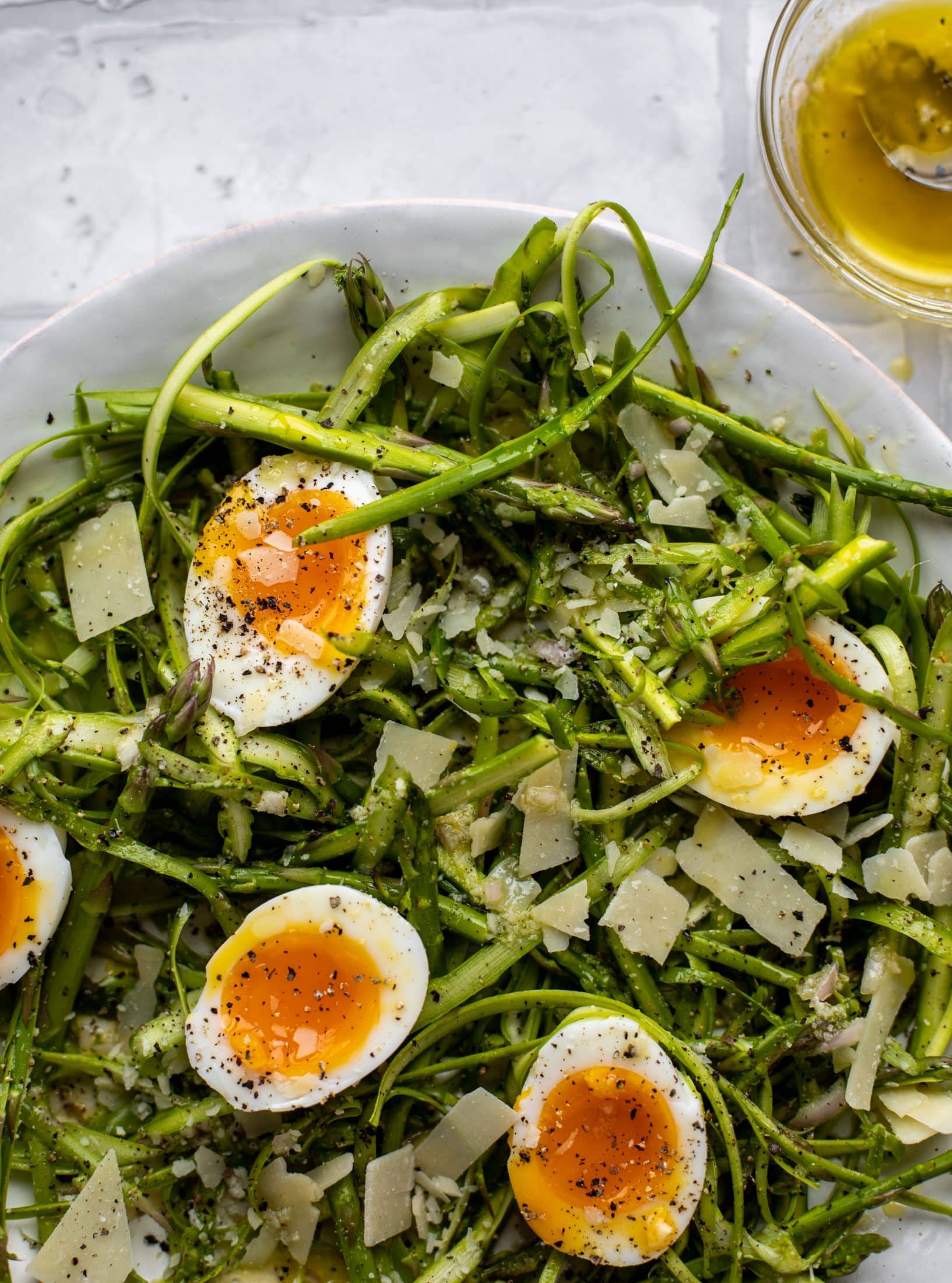 This shaved asparagus salad is tossed with a delicious parmesan vinaigrette, then topped with soft boiled eggs and finished with crunchy garlic breadcrumbs!
