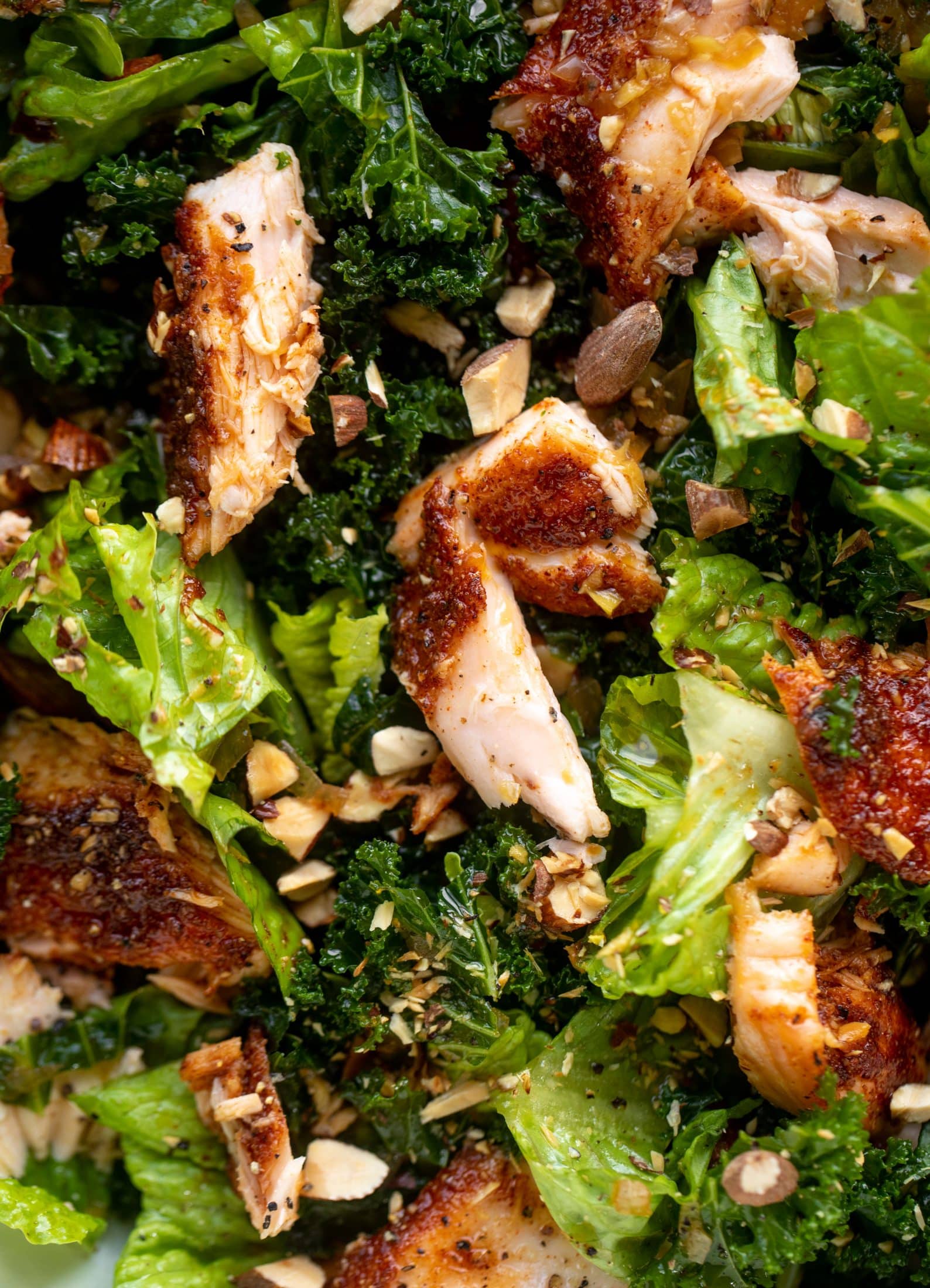 This ginger salmon salad has the flaky, flavorful roasted salmon on top of kale and romaine, drizzled with warm ginger vinaigrette.