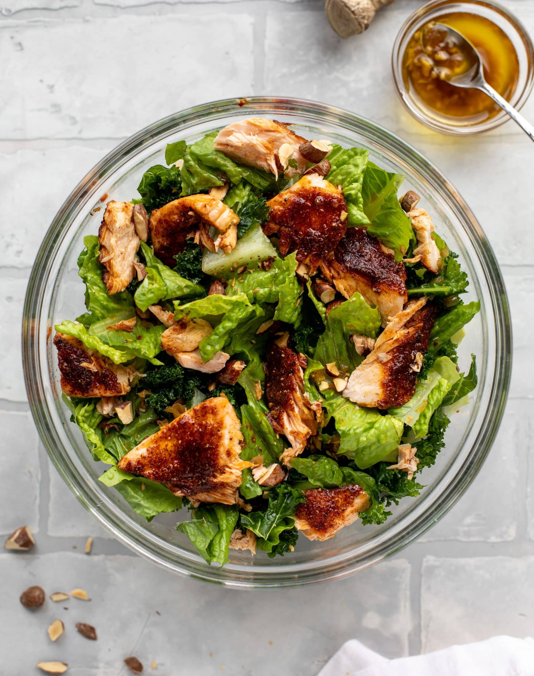 This ginger salmon salad has the flaky, flavorful roasted salmon on top of kale and romaine, drizzled with warm ginger vinaigrette.