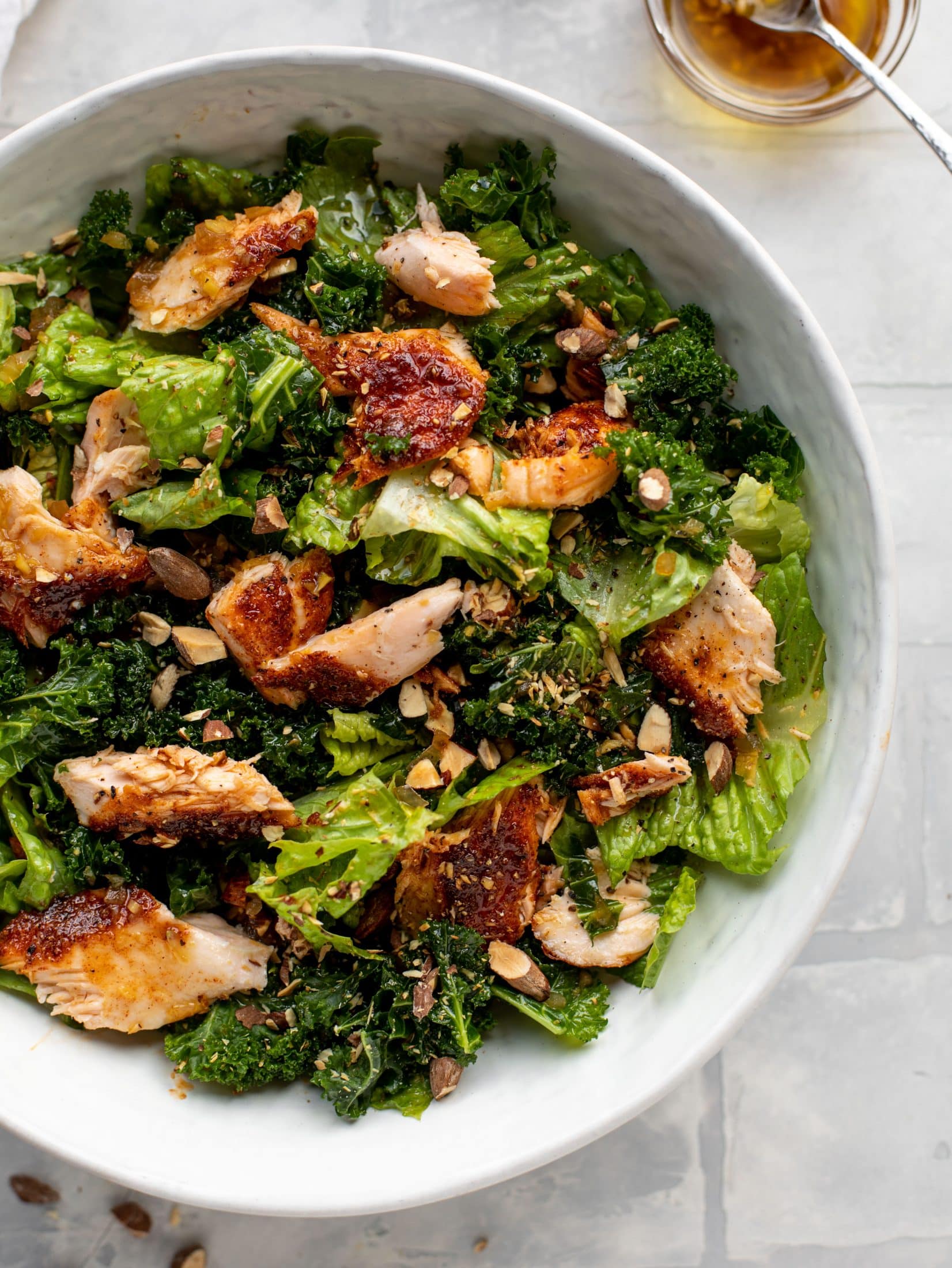 This ginger salmon salad has the flaky, flavorful roasted salmon on top of kale and romaine, drizzled with warm ginger vinaigrette.