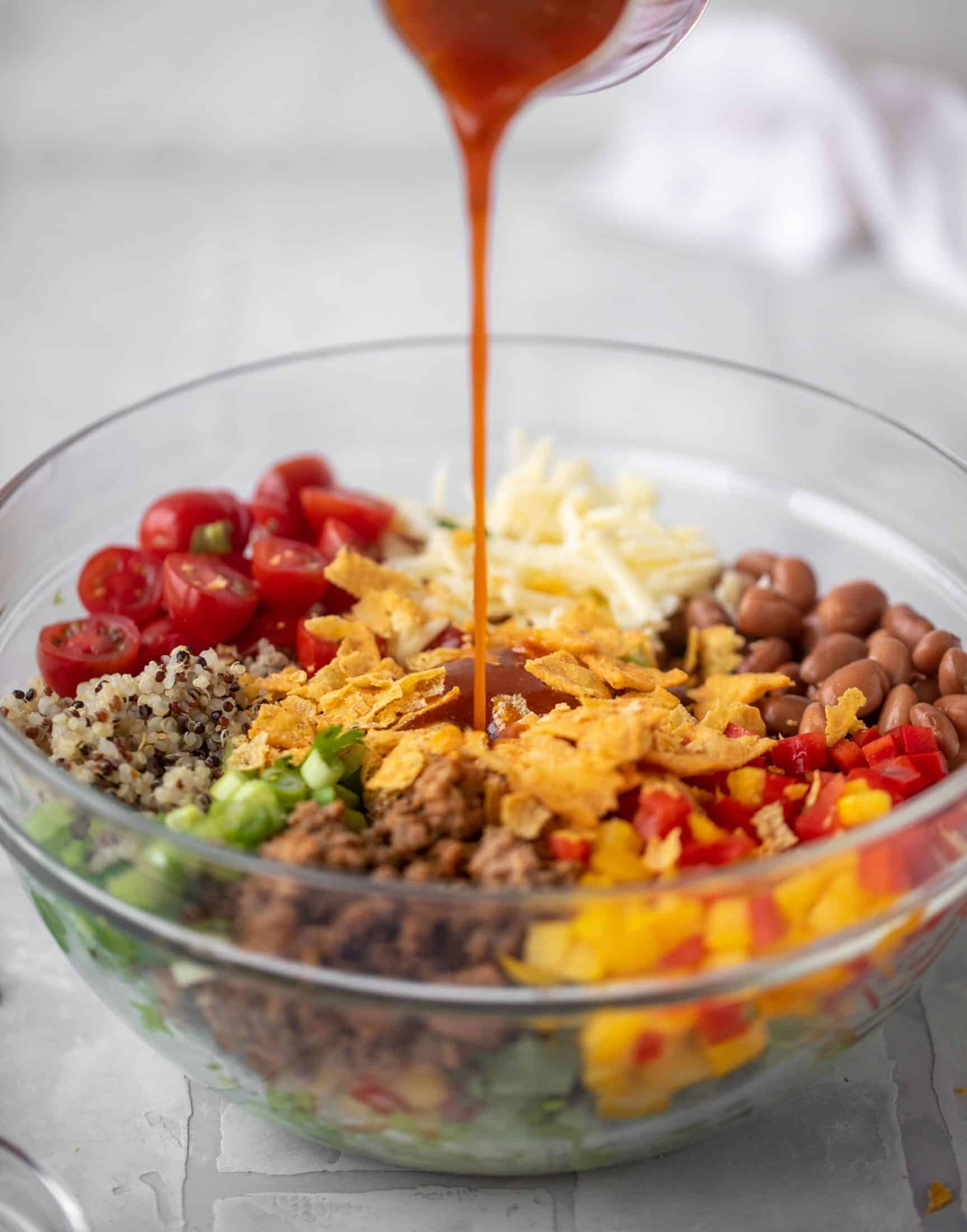 pouring catalina dressing onto taco salad