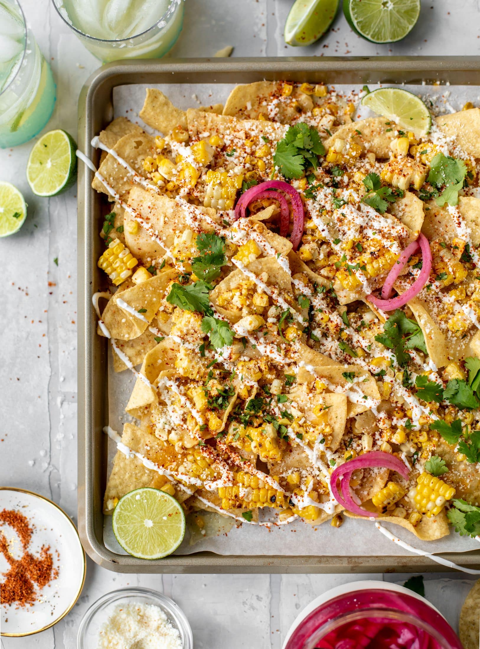 These sheet pan street corn nachos are ridiculously easy and delicious! Grilled corn, chili, lime, tons of cheese and all the flavor you could dream of!