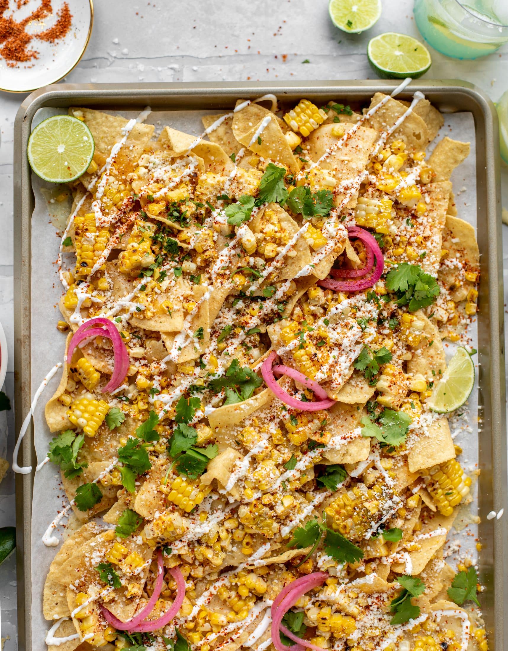 These sheet pan street corn nachos are ridiculously easy and delicious! Grilled corn, chili, lime, tons of cheese and all the flavor you could dream of!