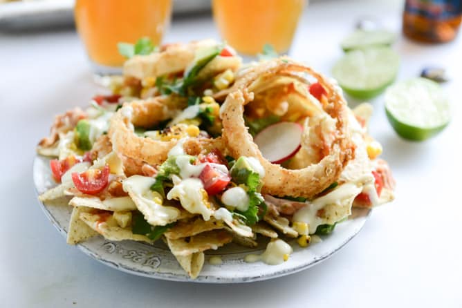 summer BBQ chicken nachos with buttermilk onion rings and white cheddar queso I howsweeteats.com