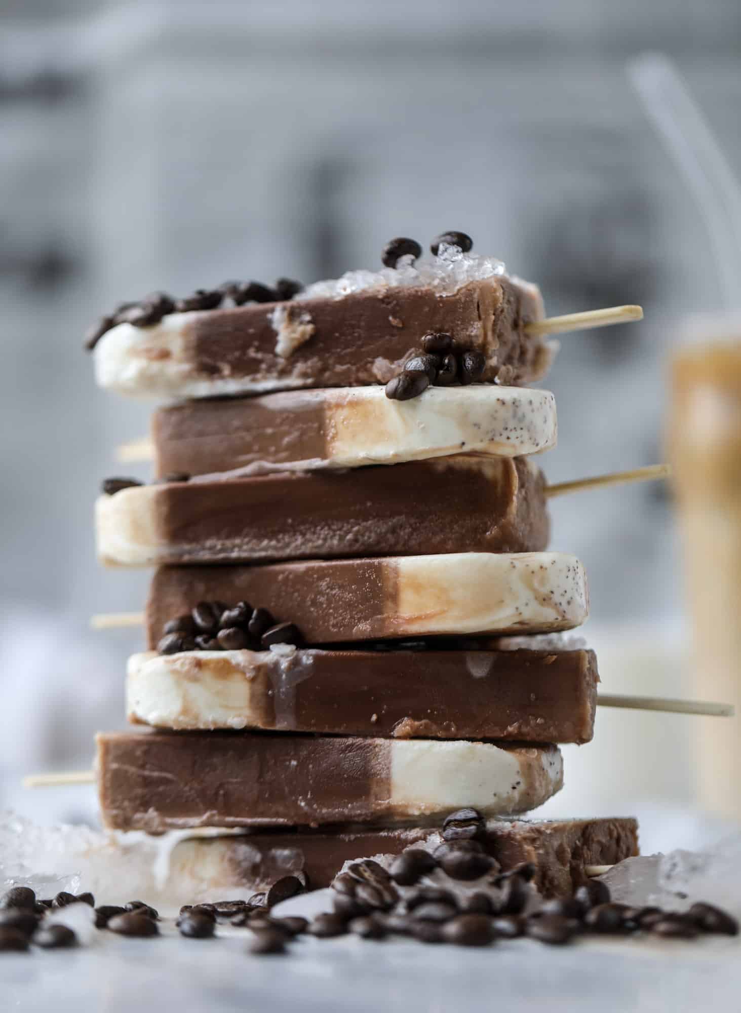 These fudgesicles are made with cold brew and dutch process cocoa for the most fun grown-up popsicle that can also deliver a little caffeine jolt. Topped with vanilla bean sweet cream, these are just like an iced latte in a pop! Serve as a treat or a snack! I howsweeteats.com #coldbrew #coffee #sweet #cream #popsicle #fudgesicle
