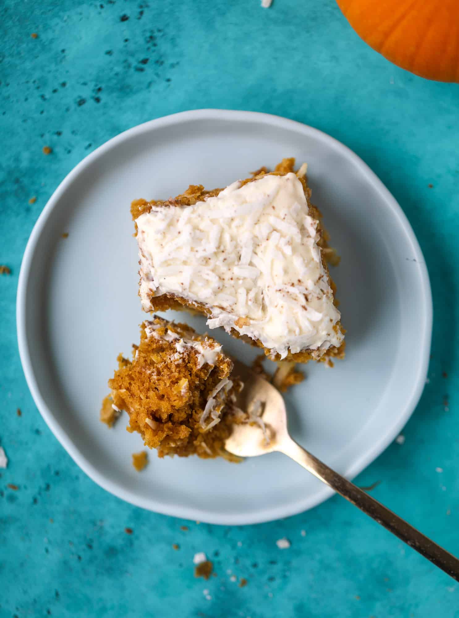 This pumpkin coconut cake is super tender and delicious and comes together quickly in a baking dish! It's spiced for the season and covered in a fluffy coconut cream cheese frosting. You can made it ahead of time for a crowd and it's a huge hit! I howsweeteats.com #pumpkin #cake