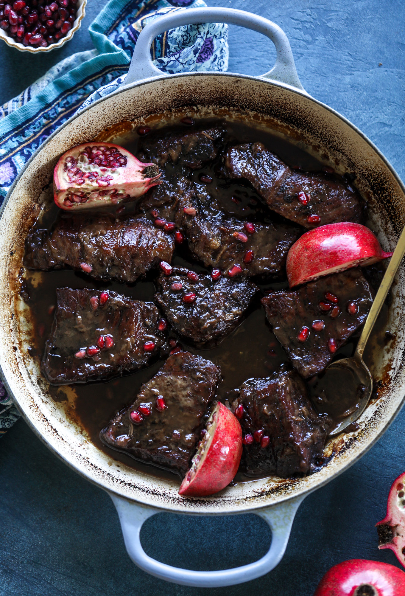 These pomegranate braised short ribs are an incredible take on comfort food! Pomegranate juice and molasses are the base of the recipe and after braising, you're left with tender, juicy and flavorful beef that is amazing served with polenta, potatoes or even in tacos. I howsweeteats.com #braised #shortribs
