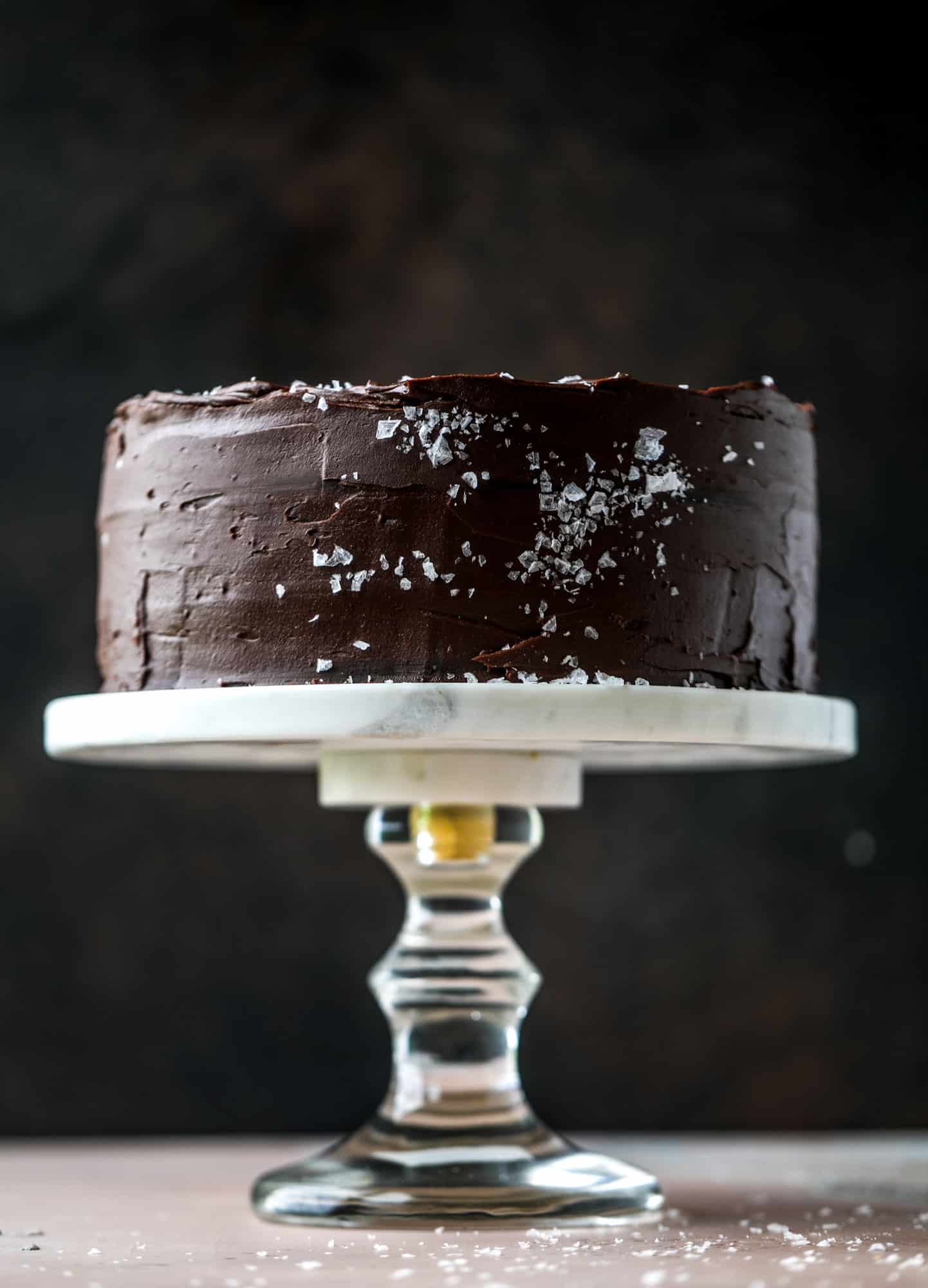 This salted dark chocolate stout cake is absolutely divine! It's ridiculously rich and perfect for a crowd or a party. Pumpkin stout batter is baked into fluffy laters and covered in a super fudgy chocolate ganache. Perfect for chocolate lovers! I howsweeteats.com #dark #chocolate #stout #cake #salted