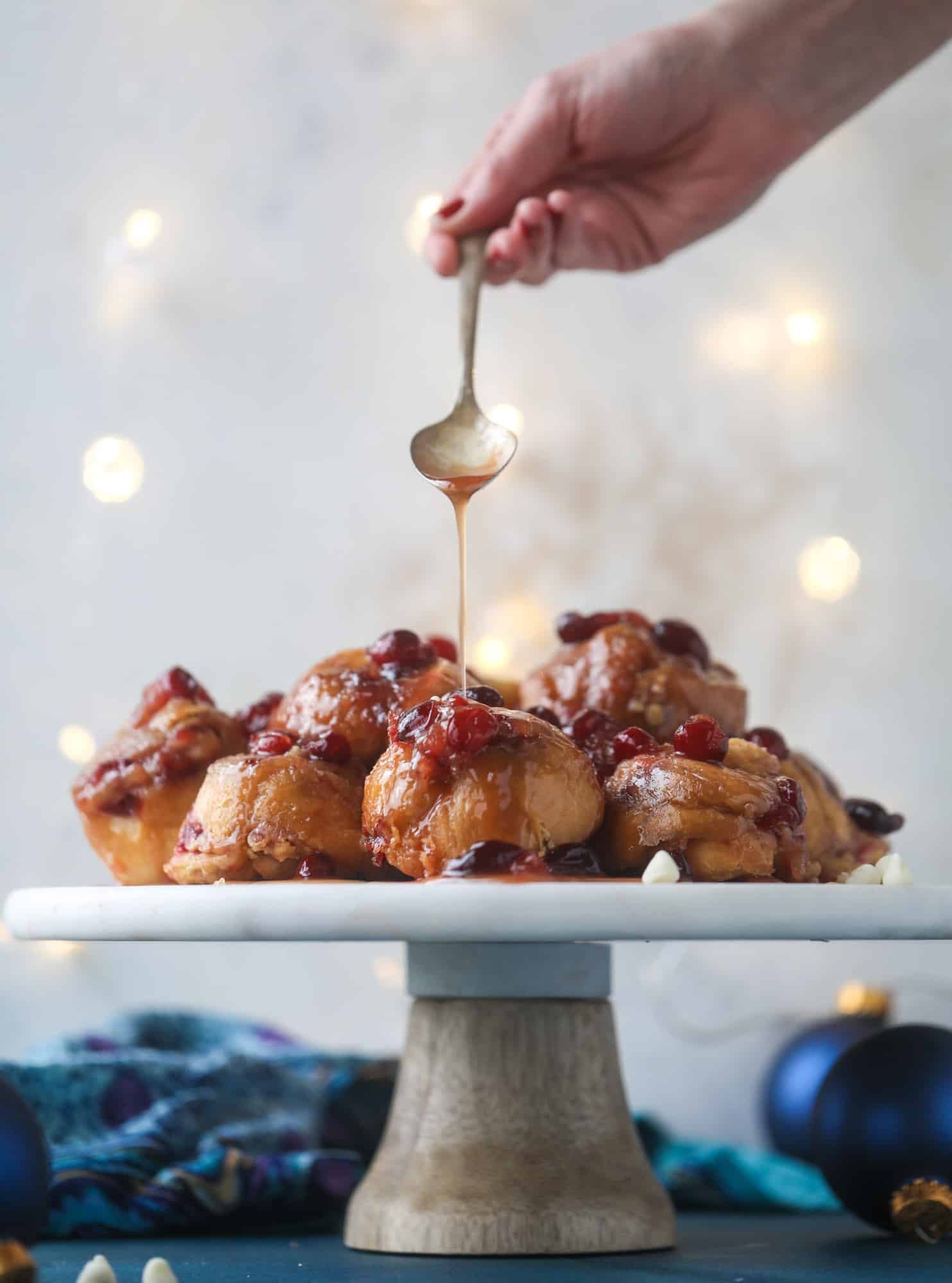 These white chocolate cranberry sticky buns are what holiday dreams are made of! Made in a muffin tin with fresh cranberries and creamy white chocolate, they are drizzled with cranberry caramel too! Dreamy! I howsweeteats.com #sticky #buns