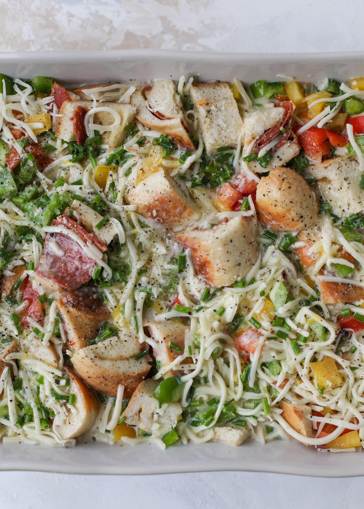 This breakfast strata is super special because the base is built on pepperoni rolls! This make ahead casserole is perfect for holiday brunches or parties and tastes like a supreme pizza. It's so easy to throw together too! I howsweeteats.com #breakfast #strata