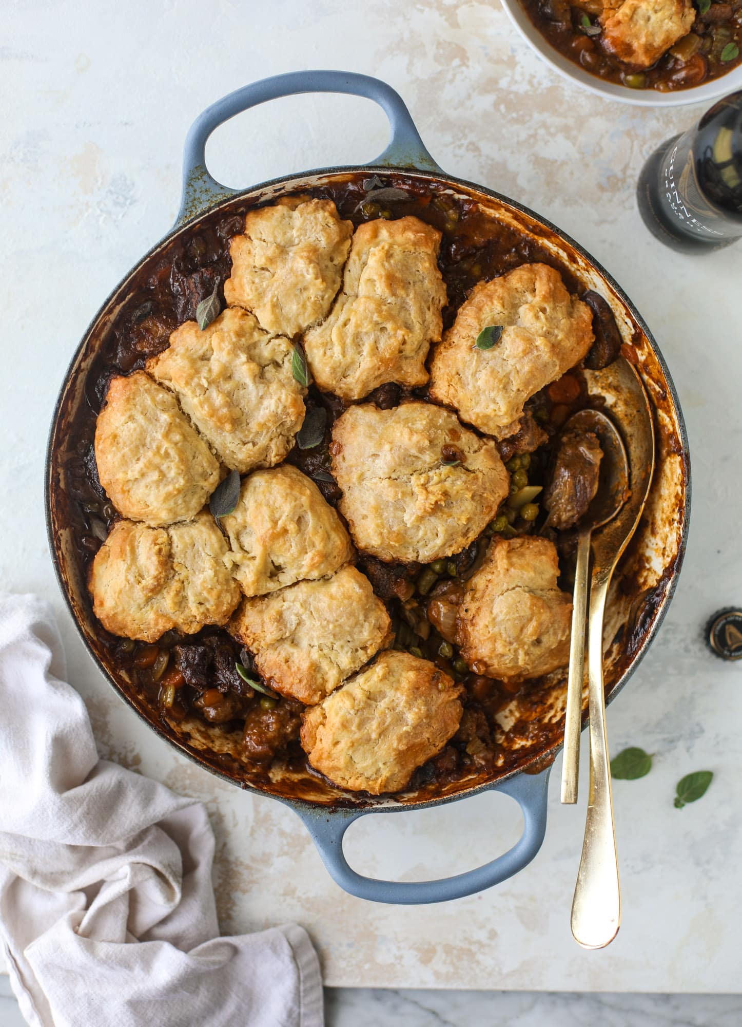 A perfect cold weather comfort food meal, Guiness pot pie has tender, fall-apart beef, lots of vegetables and is topped with buttery beer bread biscuits! I howsweeteats.com #guinness #potpie