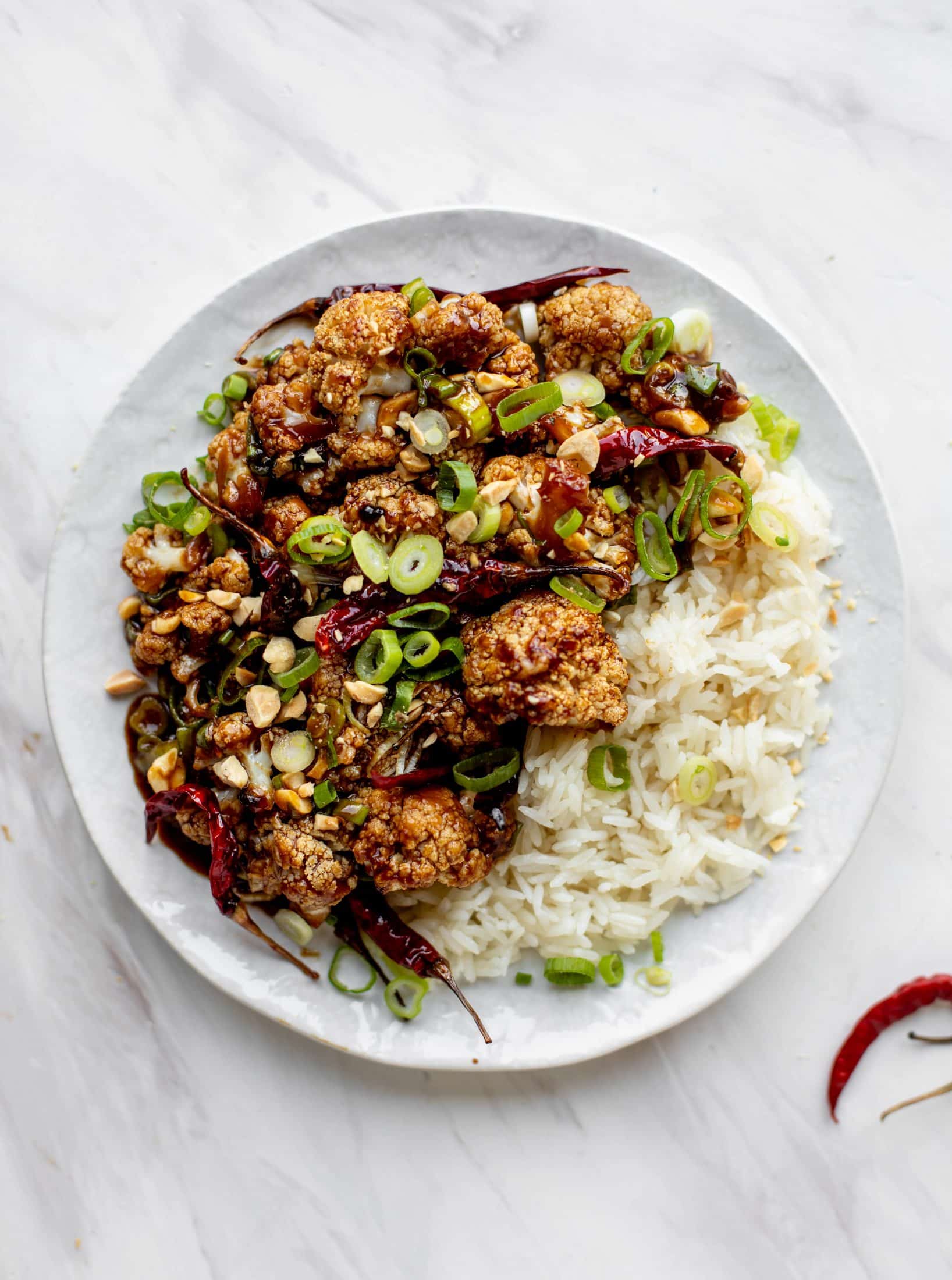 This kung pao cauliflower recipe is roasted on one sheet pan and covered in a delicious sauce! Serve alongside jasmine rice for the best dinner ever.