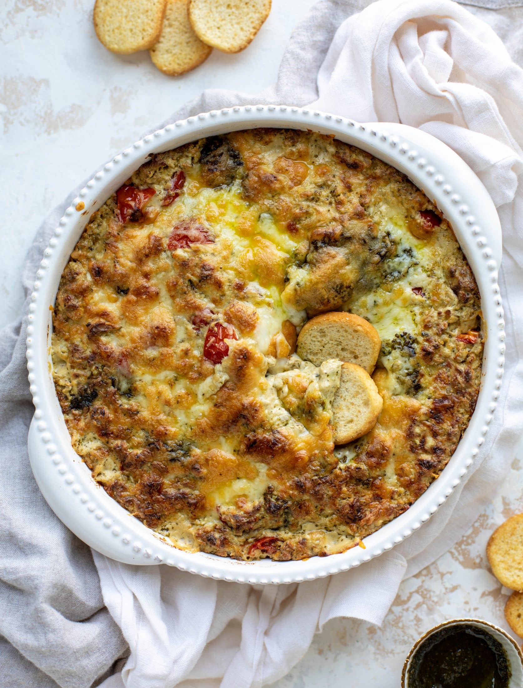This cheesy pesto chicken dip is a great way to use up your end-of-summer herbs! Lots of delicious smoky flavor and tons of bubbly cheese.