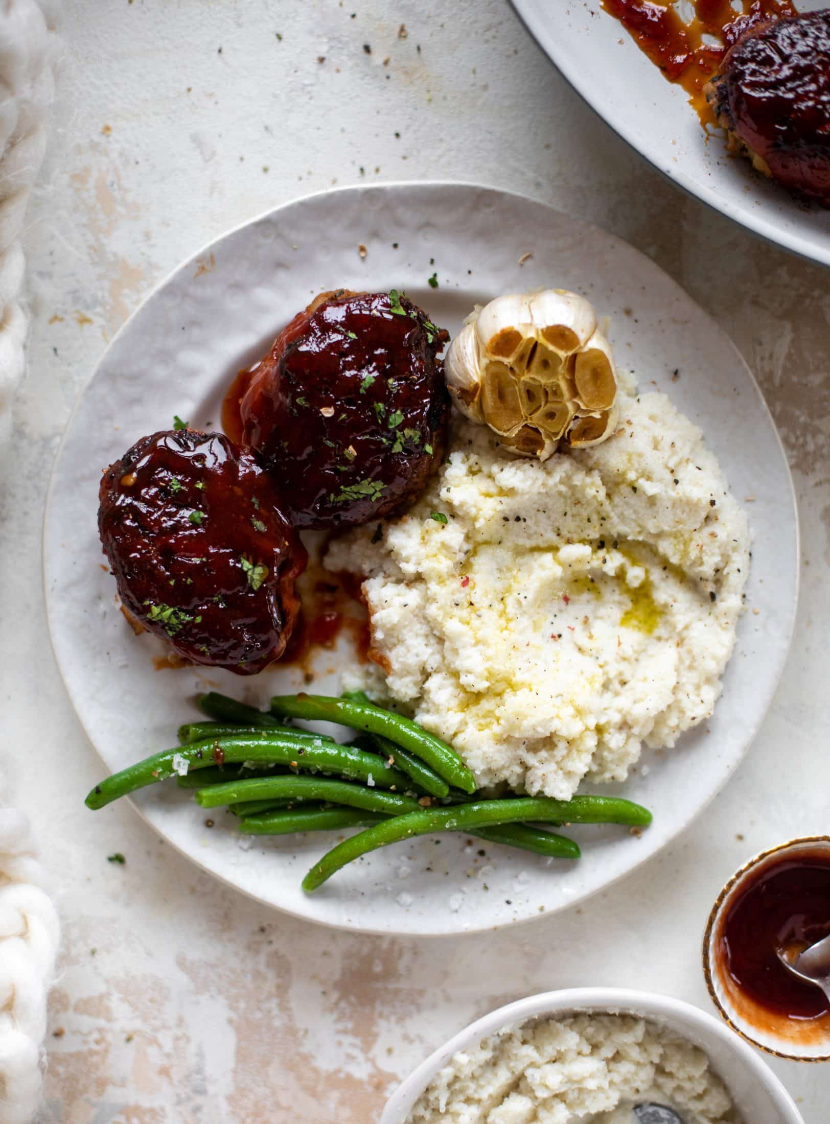 Mini turkey meatloaf in a skillet is the best weeknight dinner idea! Serve with roasted garlic cauliflower mash and your favorite green veggie on the side.