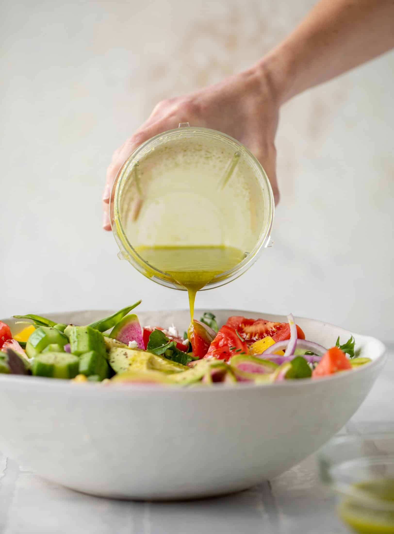 pouring vinaigrette on salad